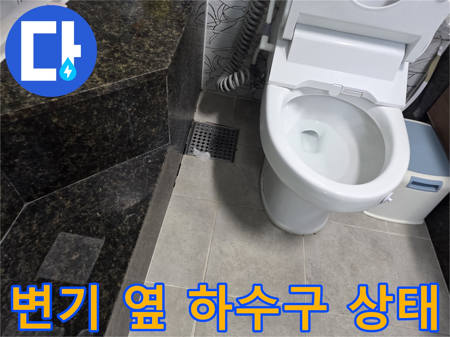 변기 근처 타일 바닥과 배수구 유가 부위의 촬영 이미지입니다.