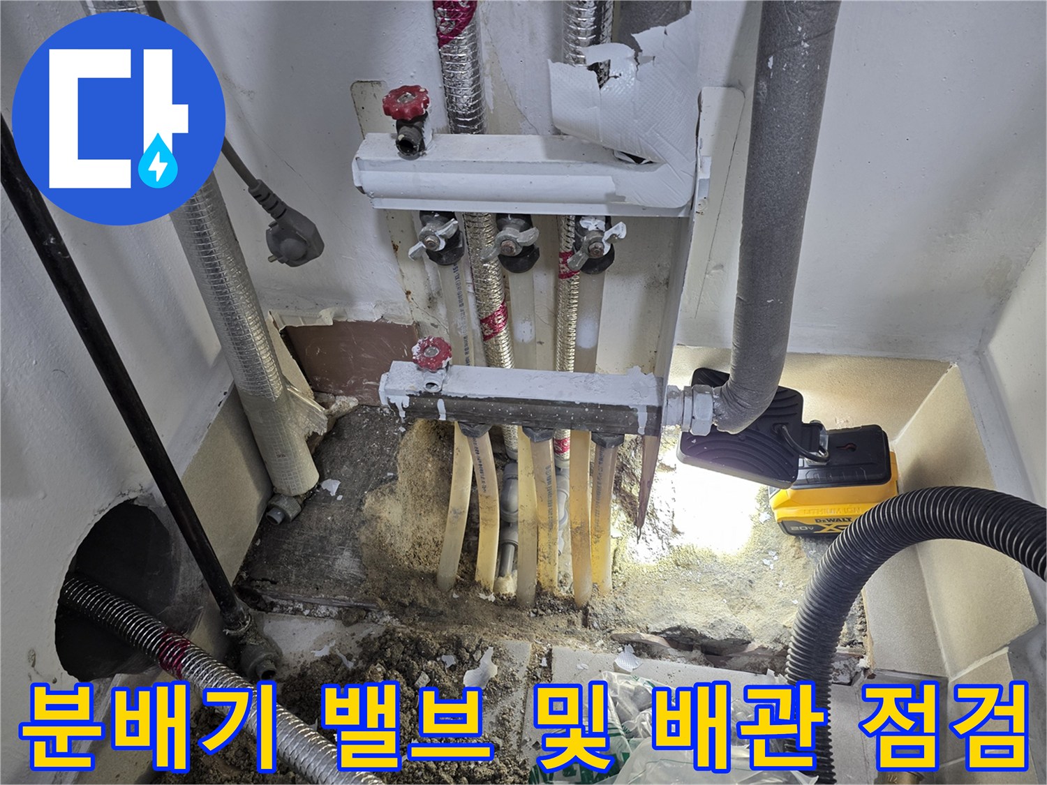 보일러 분배기의 밸브와 연결된 배관들의 결합 상태를 면밀히 검토하고 있습니다.