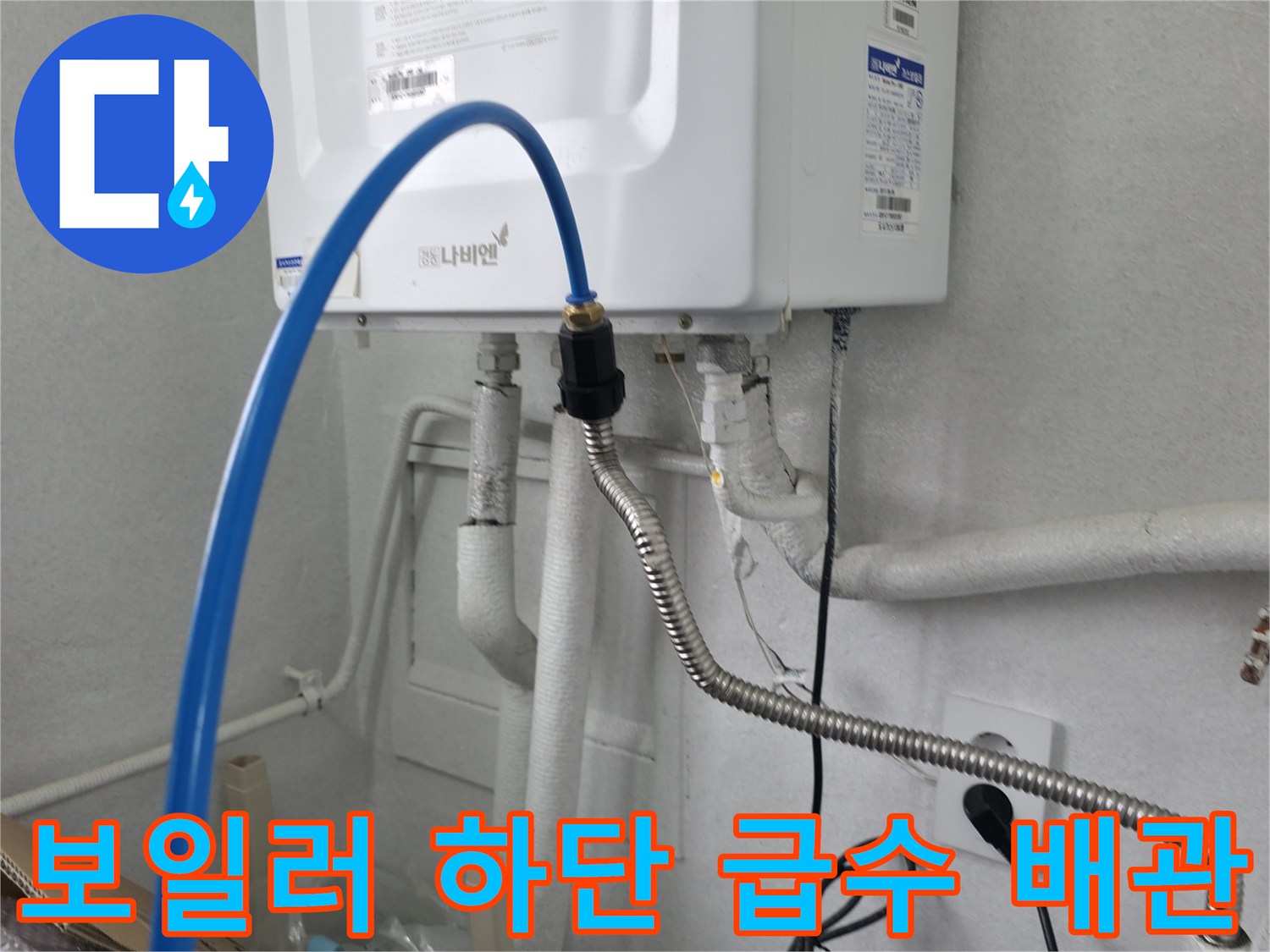 보일러 본체 아래에 연결된 파란색 호스와 금속 주름관