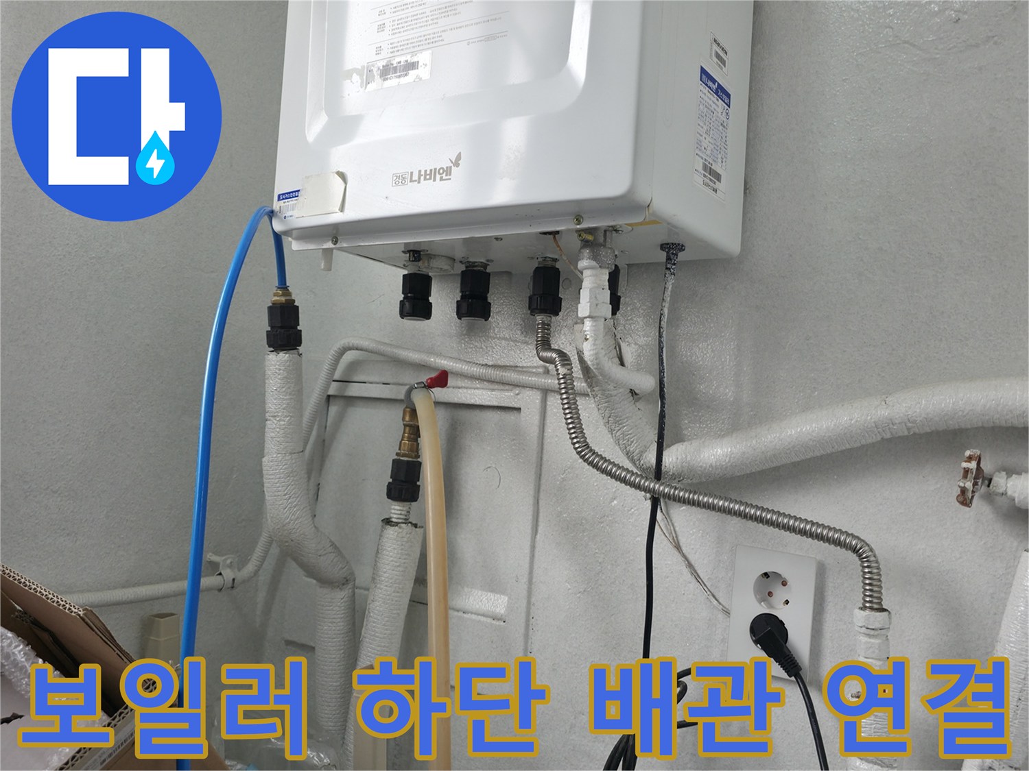 보일러 아래쪽의 다양한 배관과 호스 구성
