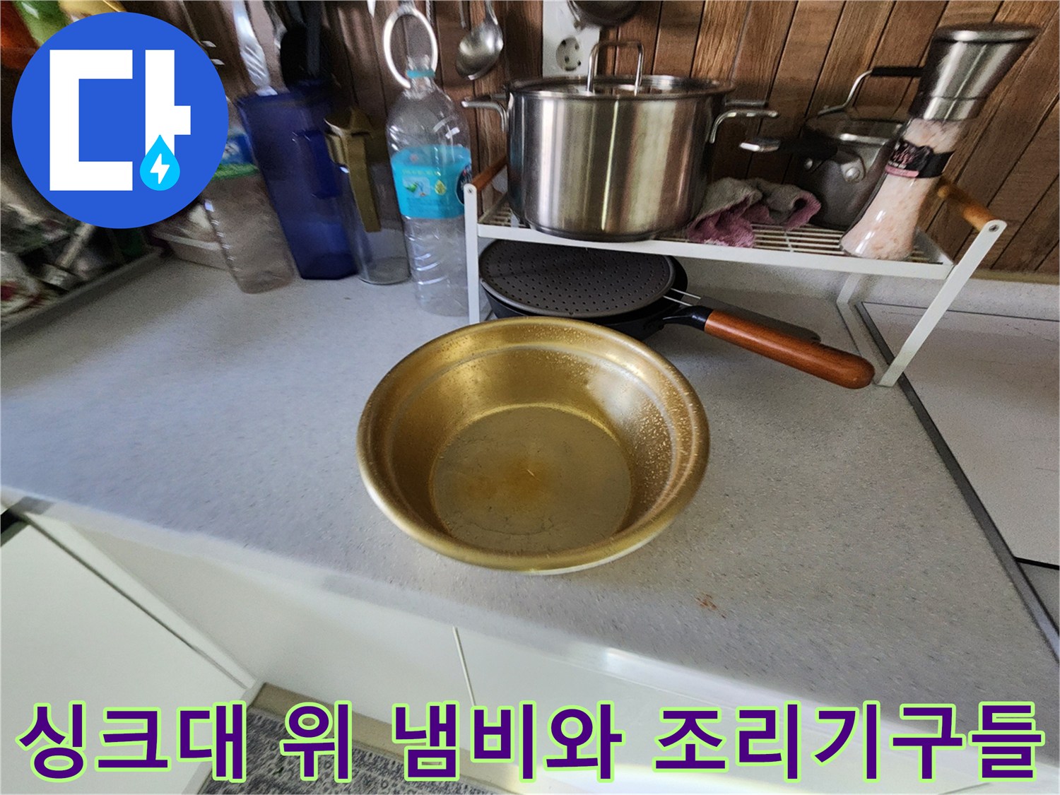 주방 싱크대 위에 놓인 다양한 금속제 용기와 그릇들
