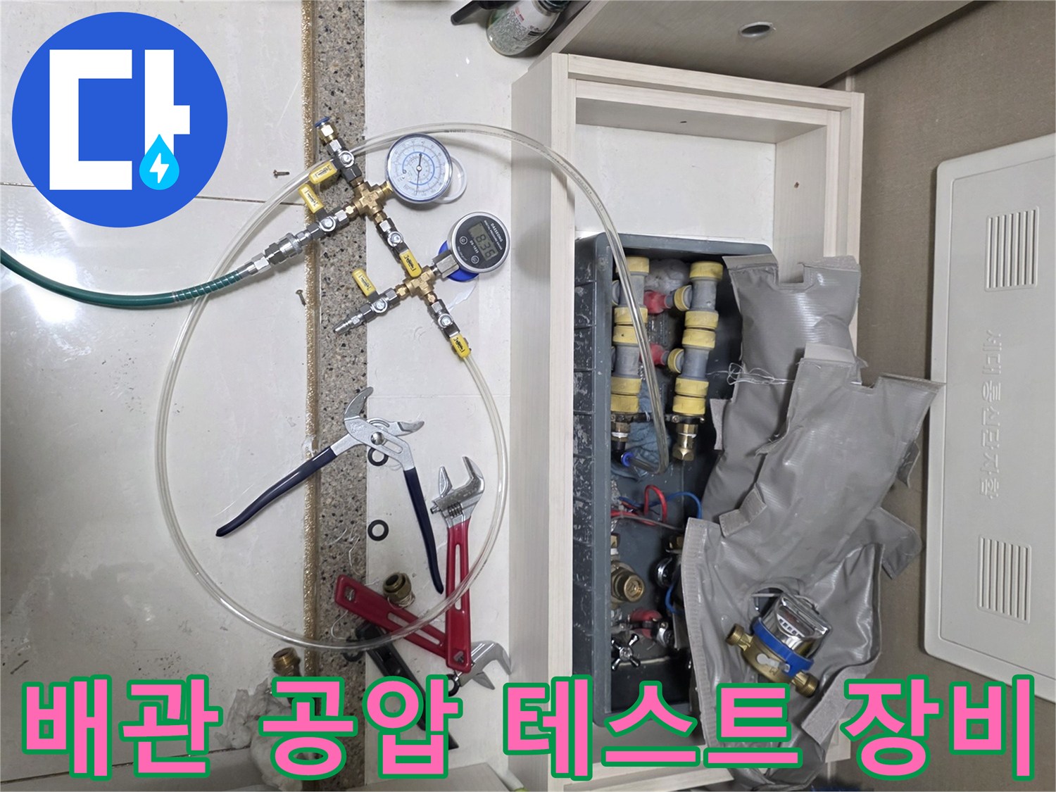 싱크대 하부 배관의 기밀성을 확인하기 위한 압력 게이지와 수공구 세트