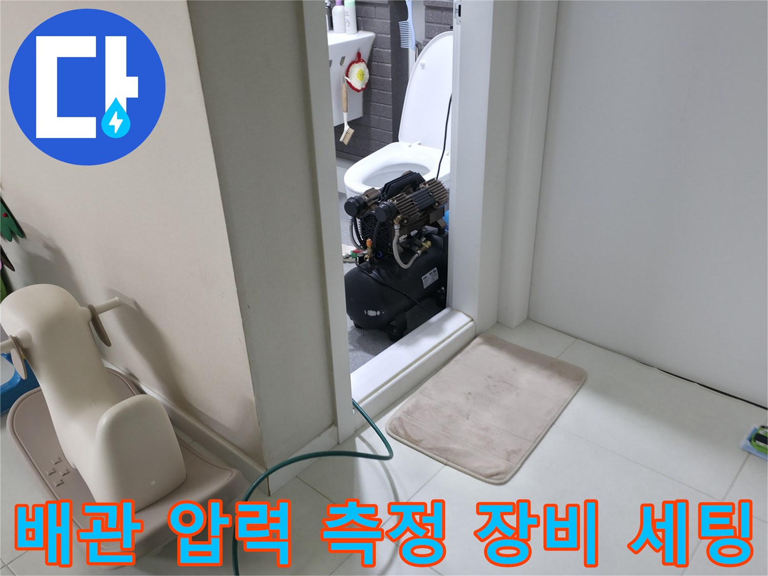 화장실 문 너머로 연결된 배관 검사용 압력 측정 기계
