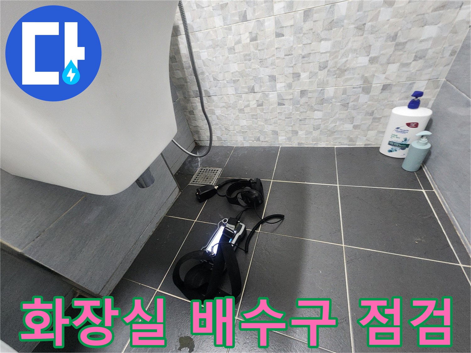 타일 바닥에 놓인 작업 도구와 배수구 주변 상황