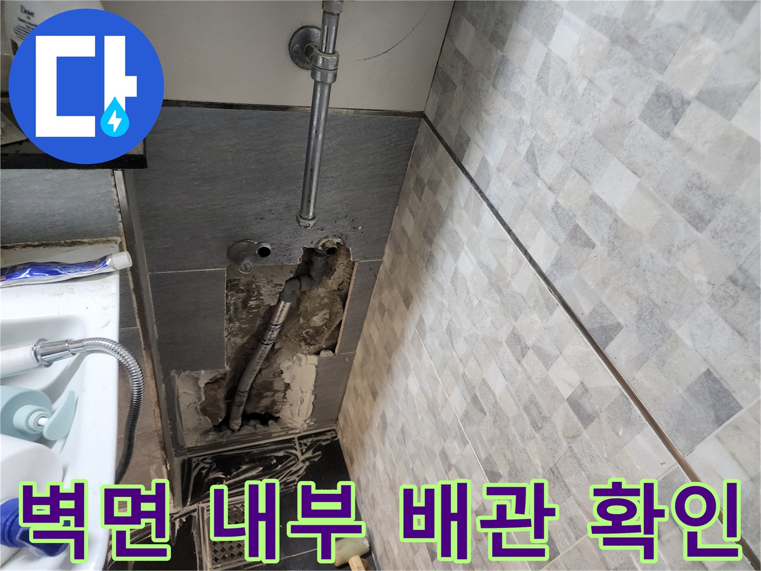타일 제거 후 드러난 젖은 시멘트와 은색 급수 배관