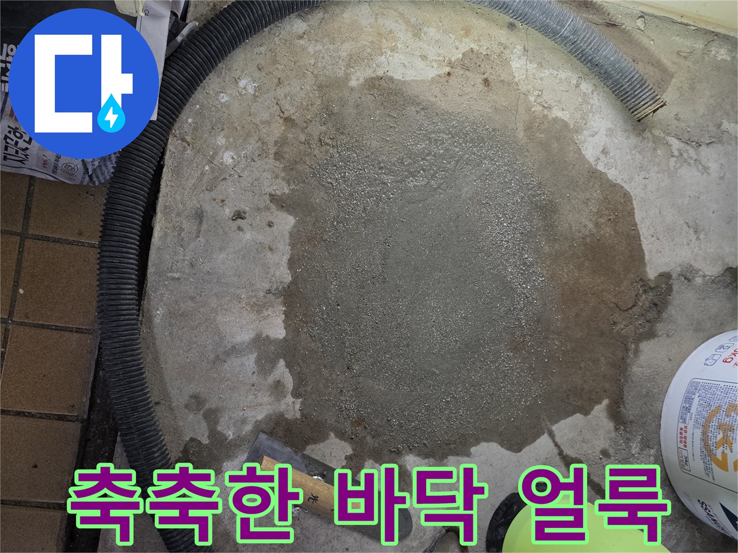 바닥면에 넓게 퍼진 누수 흔적과 작업 도구