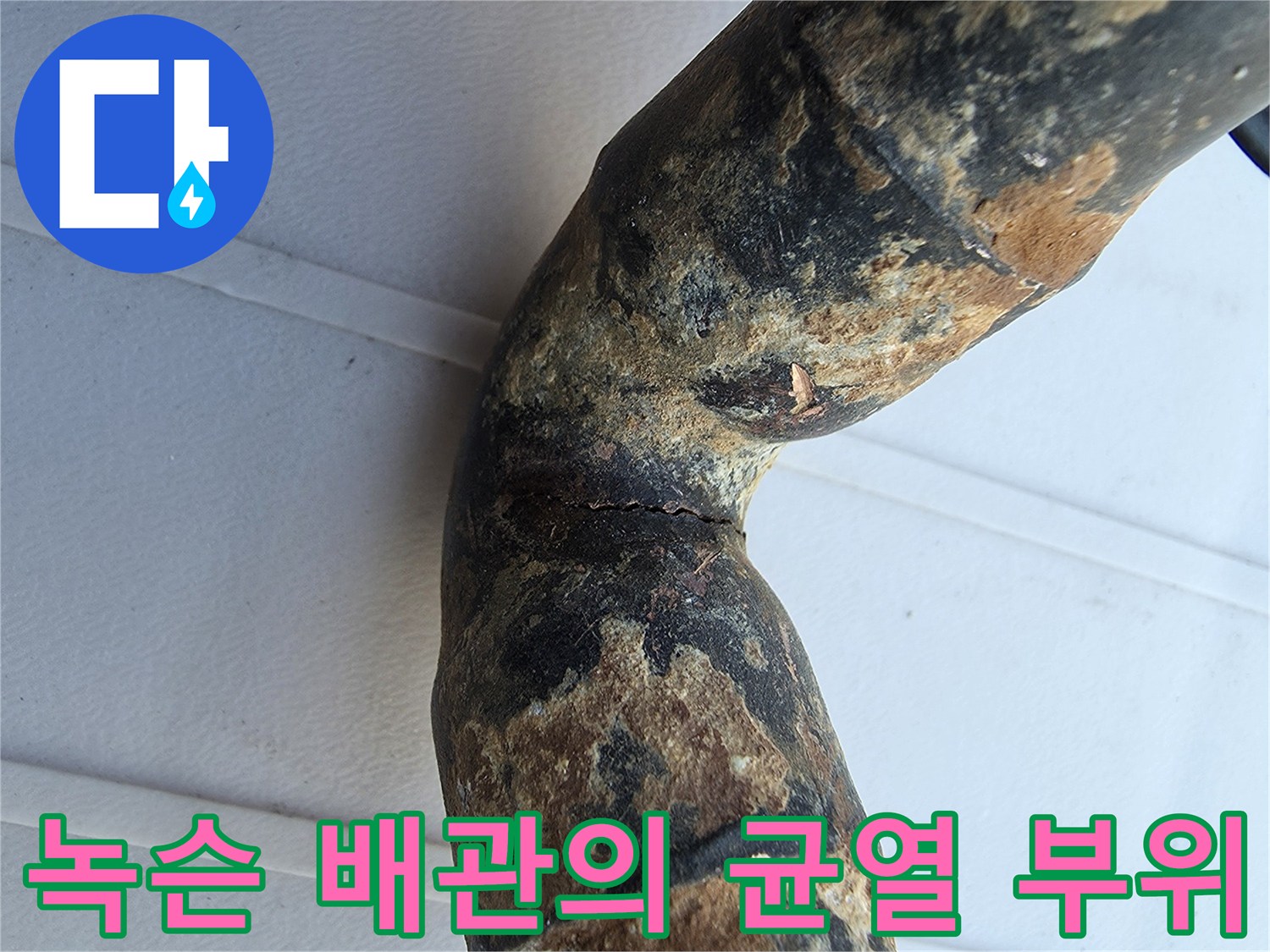 심한 부식과 함께 갈라진 금속 배관 엘보 구간