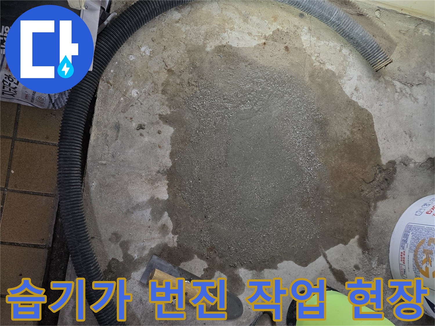 젖은 바닥과 작업 도구가 놓인 모습