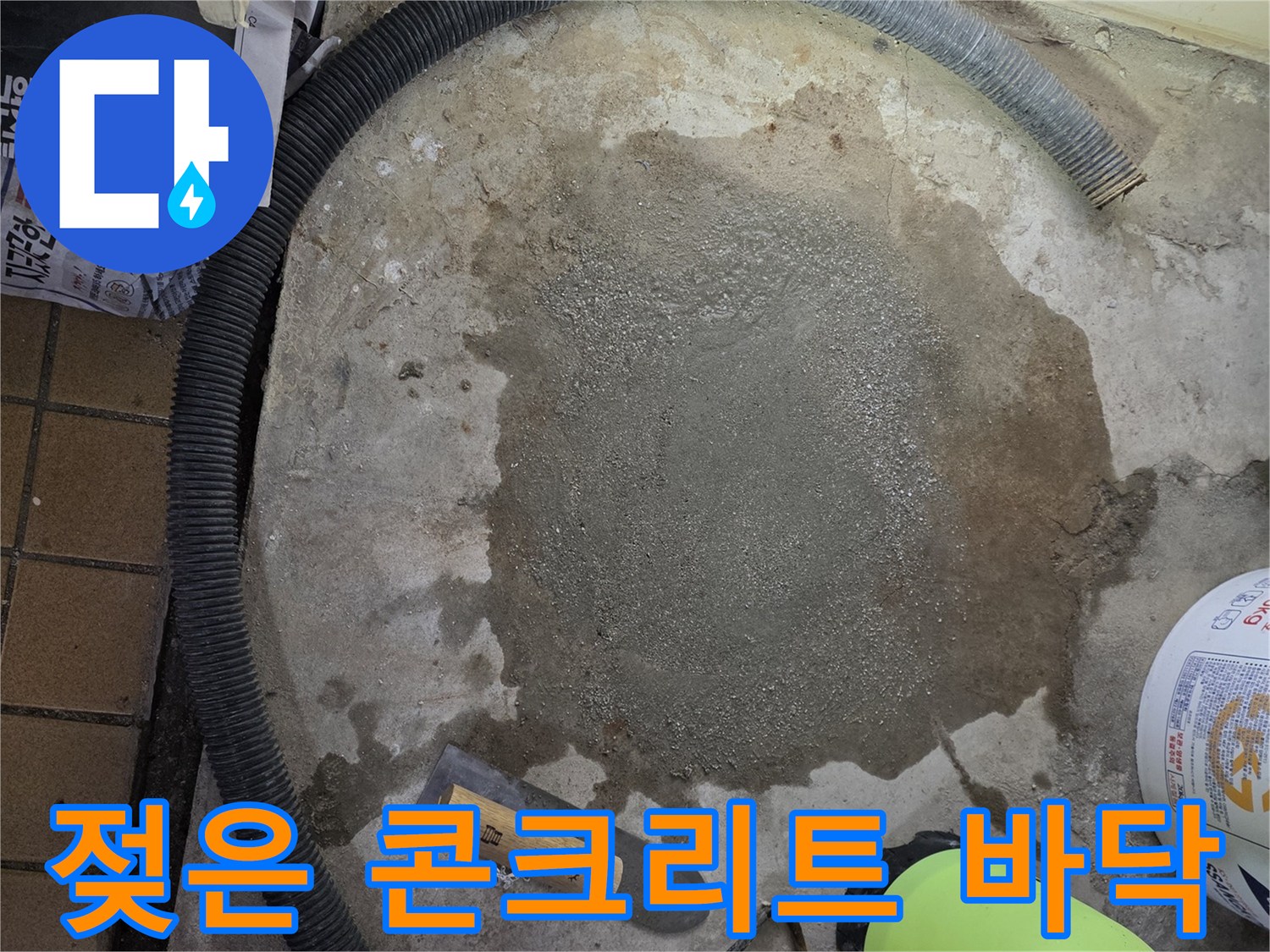 축축하게 젖어 있는 콘크리트 바닥과 작업용 도구들