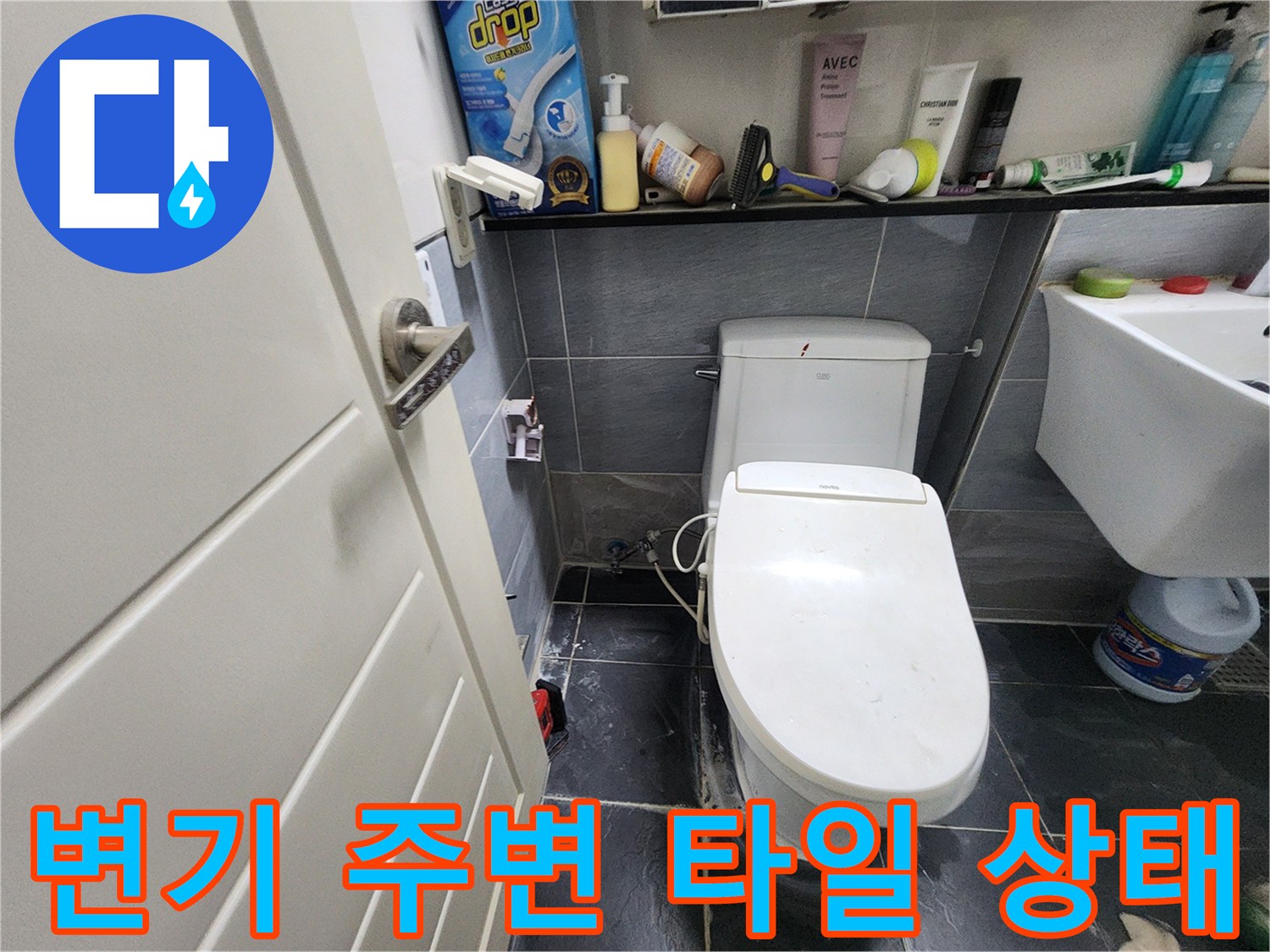 흰색 변기와 옆의 세면대가 설치된 욕실 바닥 사진입니다.