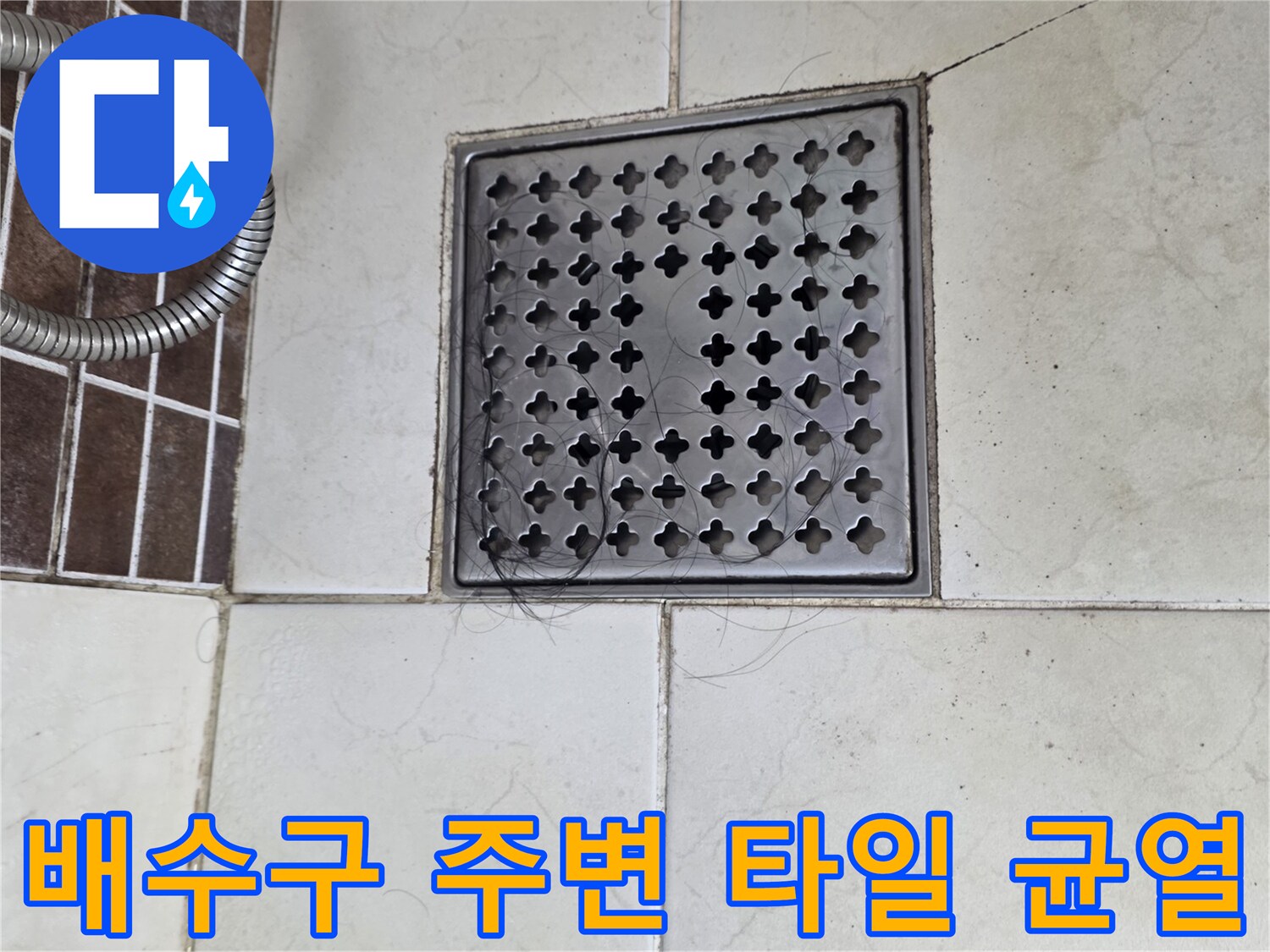 메탈 배수구 덮개와 갈라진 타일의 근접 사진