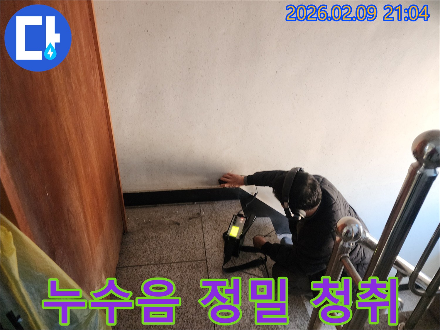 전문-기술자가-누수-탐지기를-사용하여-건물-내부의-미세한-물샘-소리를-집중적으로-듣고-있는-장면