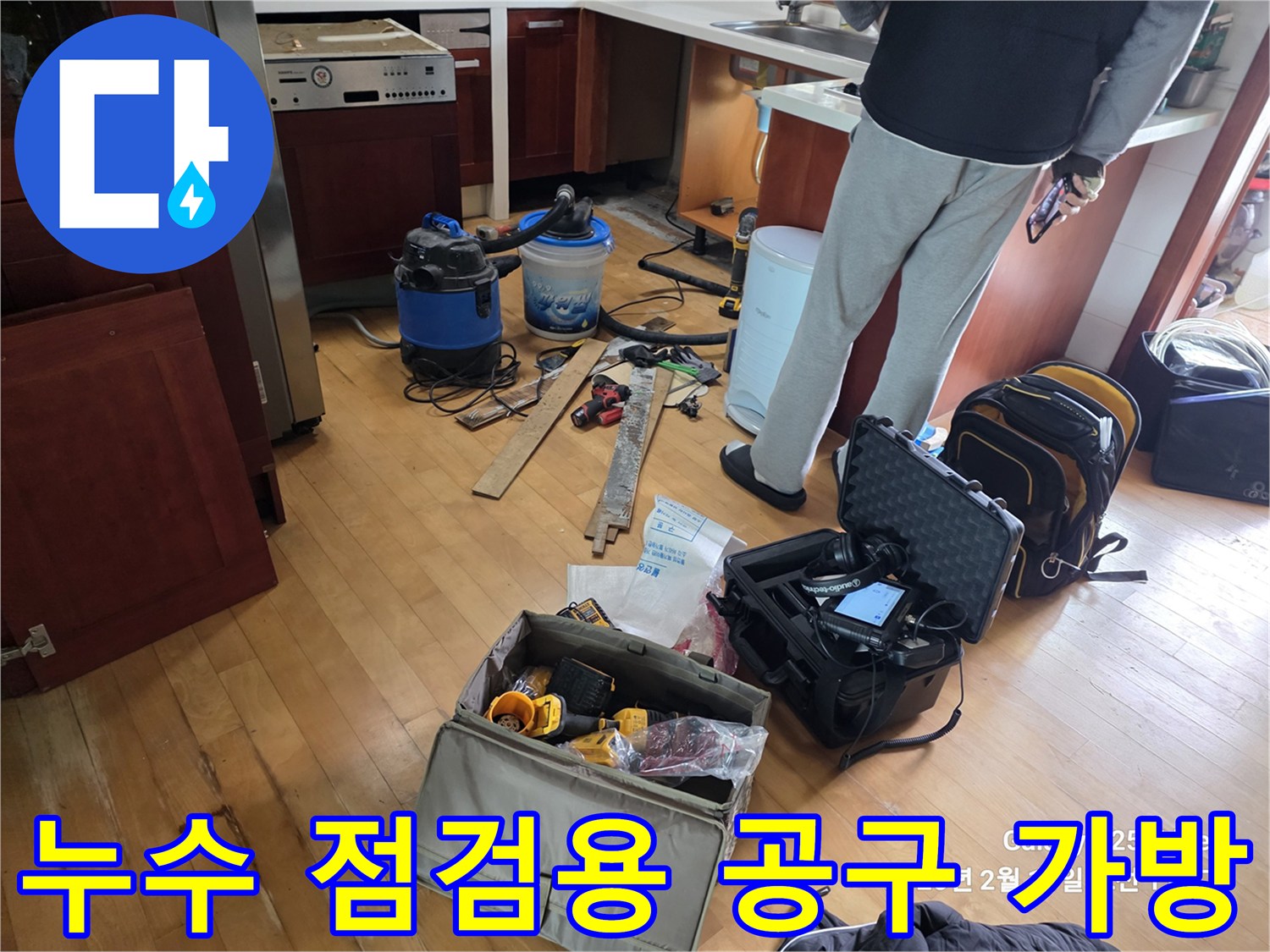 싱크대 하단 작업 공간에 놓인 다양한 누수 탐지 및 수선용 장비들