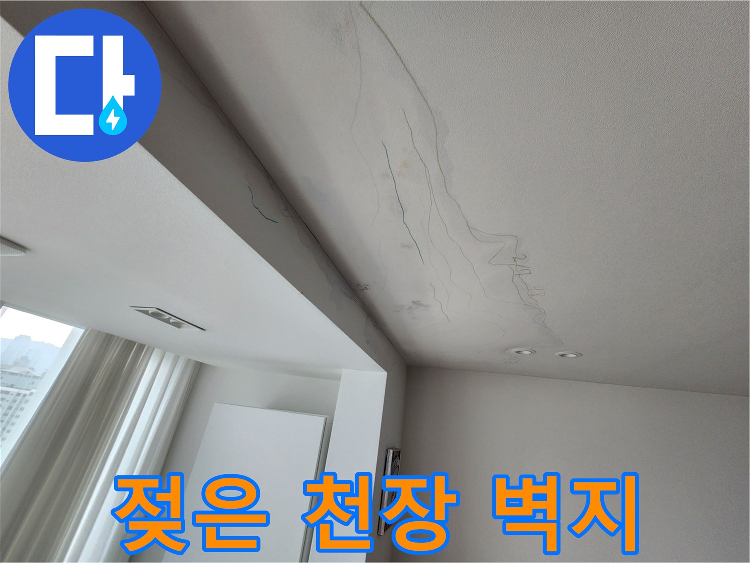 물에 젖어 어둡게 변한 거실 천장 벽지의 누수 흔적