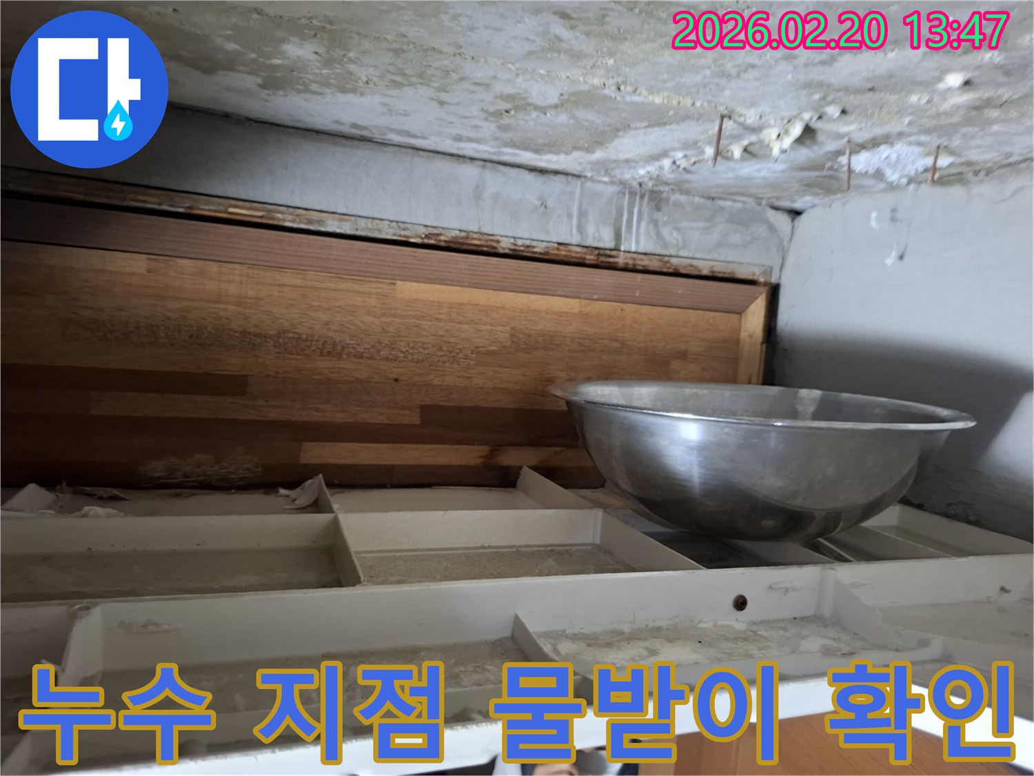천장에서 물이 떨어져-임시로 물을 받고 있는-누수 현장의 모습이 담긴 사진입니다