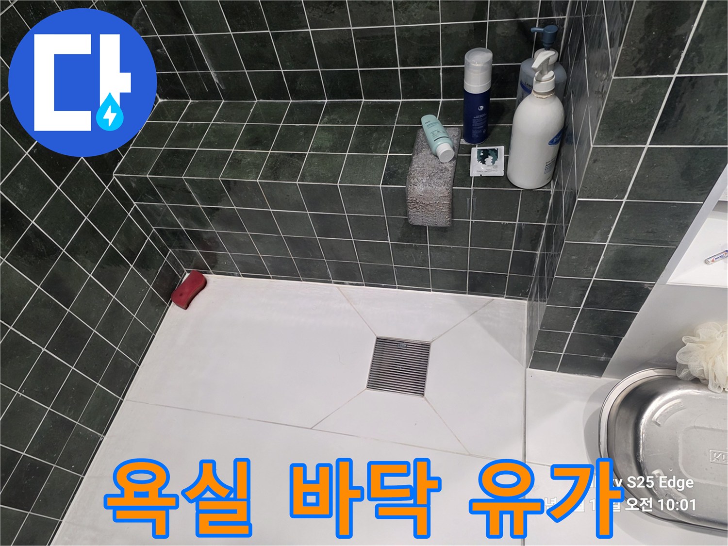 하얀색 바닥재와 녹색 타일 사이의 배수구 시설