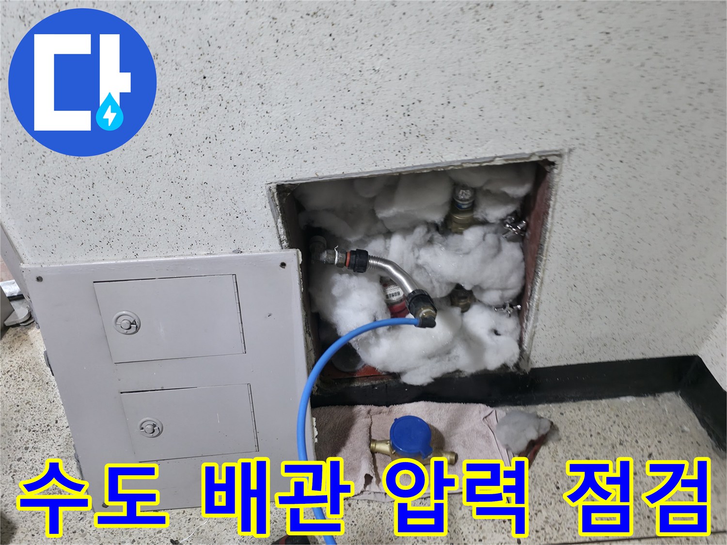 내부 노출 배관-파란색 호스가 연결된 수도 부속의 모습