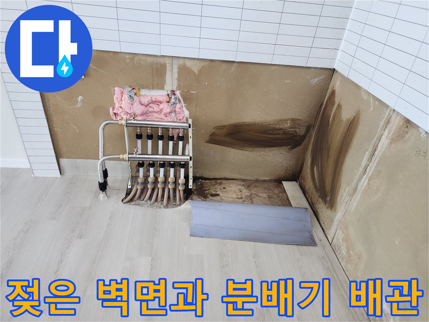 분배기 연결 부위 주변의 젖은 흔적과 오염된 벽면 사진입니다.