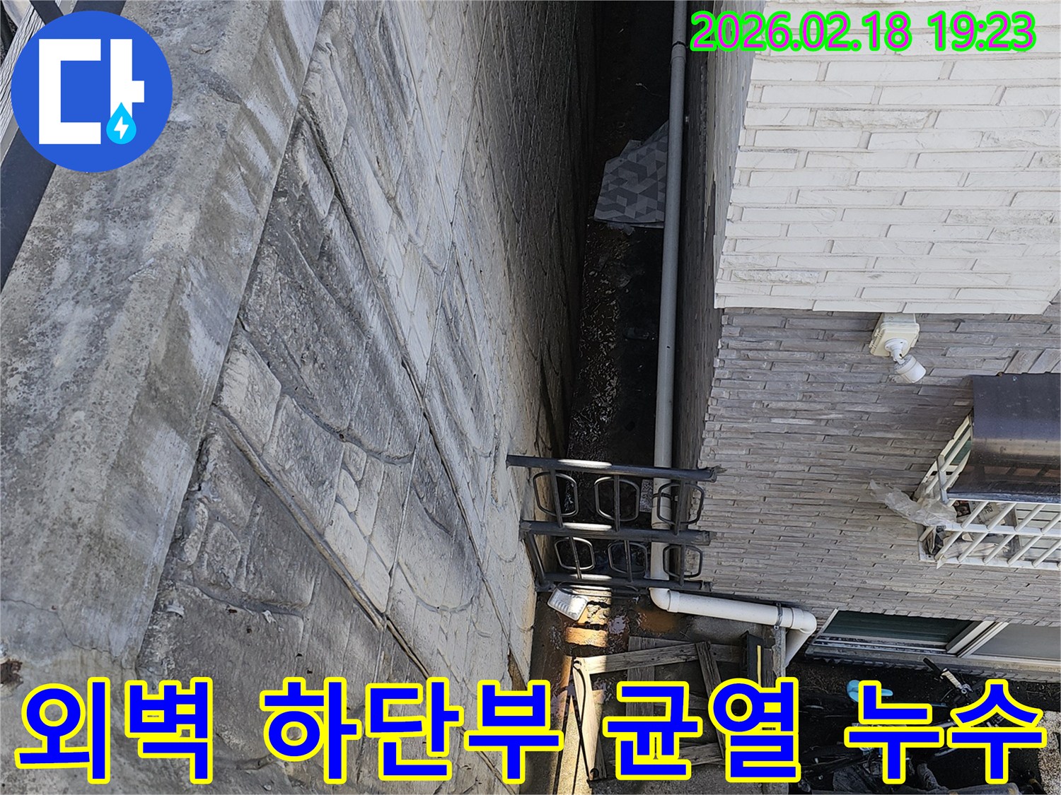 일산동구 숲속마을 빌라 외벽 하단부에서 발생한 균열로 인한-누수를 보수하기 위해 전문가가 현장을 진단하는 모습입니다