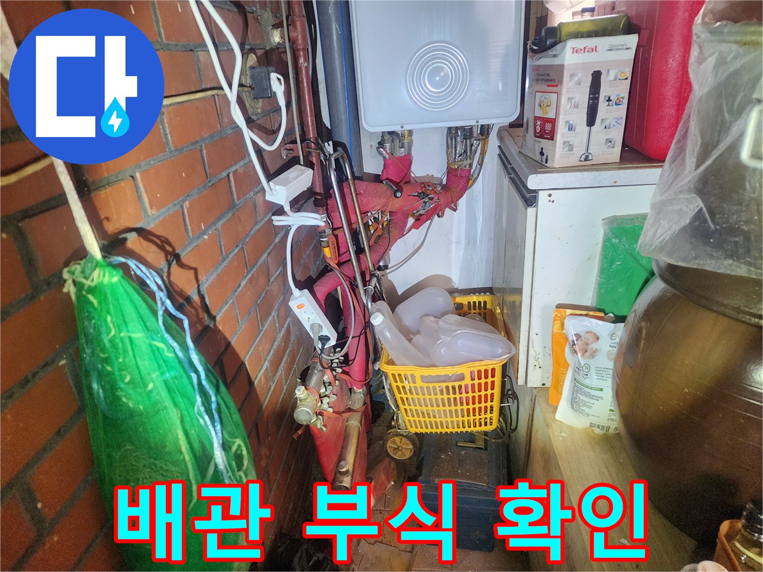 붉은색 보온재로 감겨 있는-노후된 배관 연결 부위의 모습