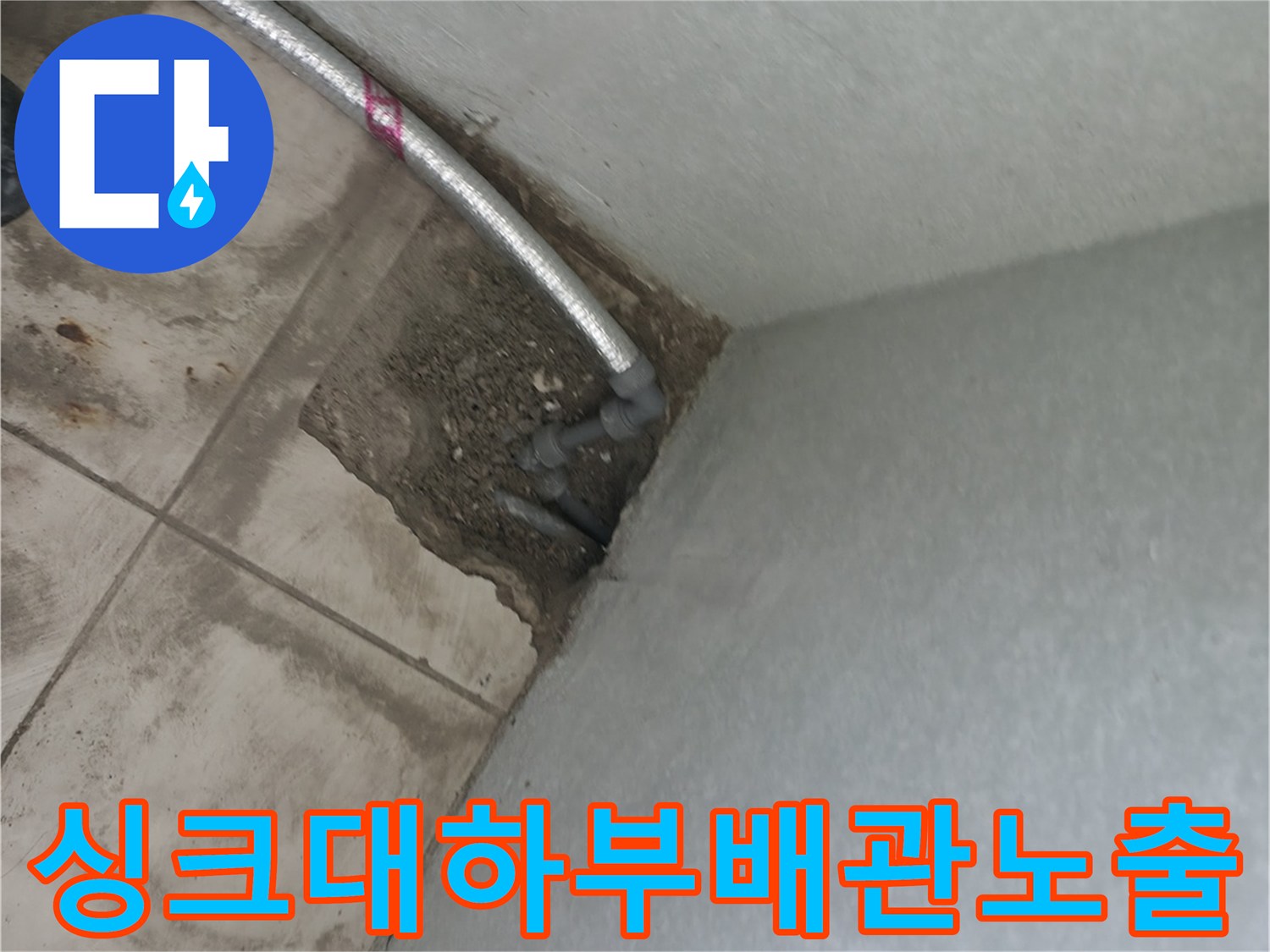 싱크대 하부 타일 아래 노출된 금속 배관 부위