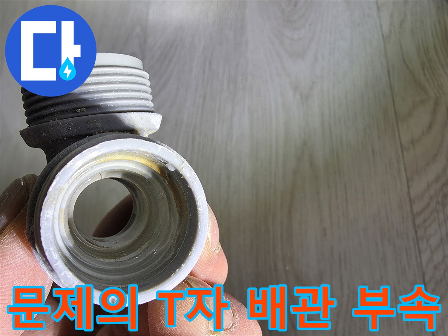 누수가 발생한 회색 플라스틱 분기 배관 부품