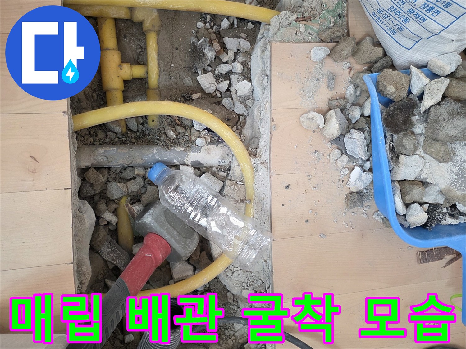 바닥을 파내어 드러난 노란색 수도 배관과 주변 자재