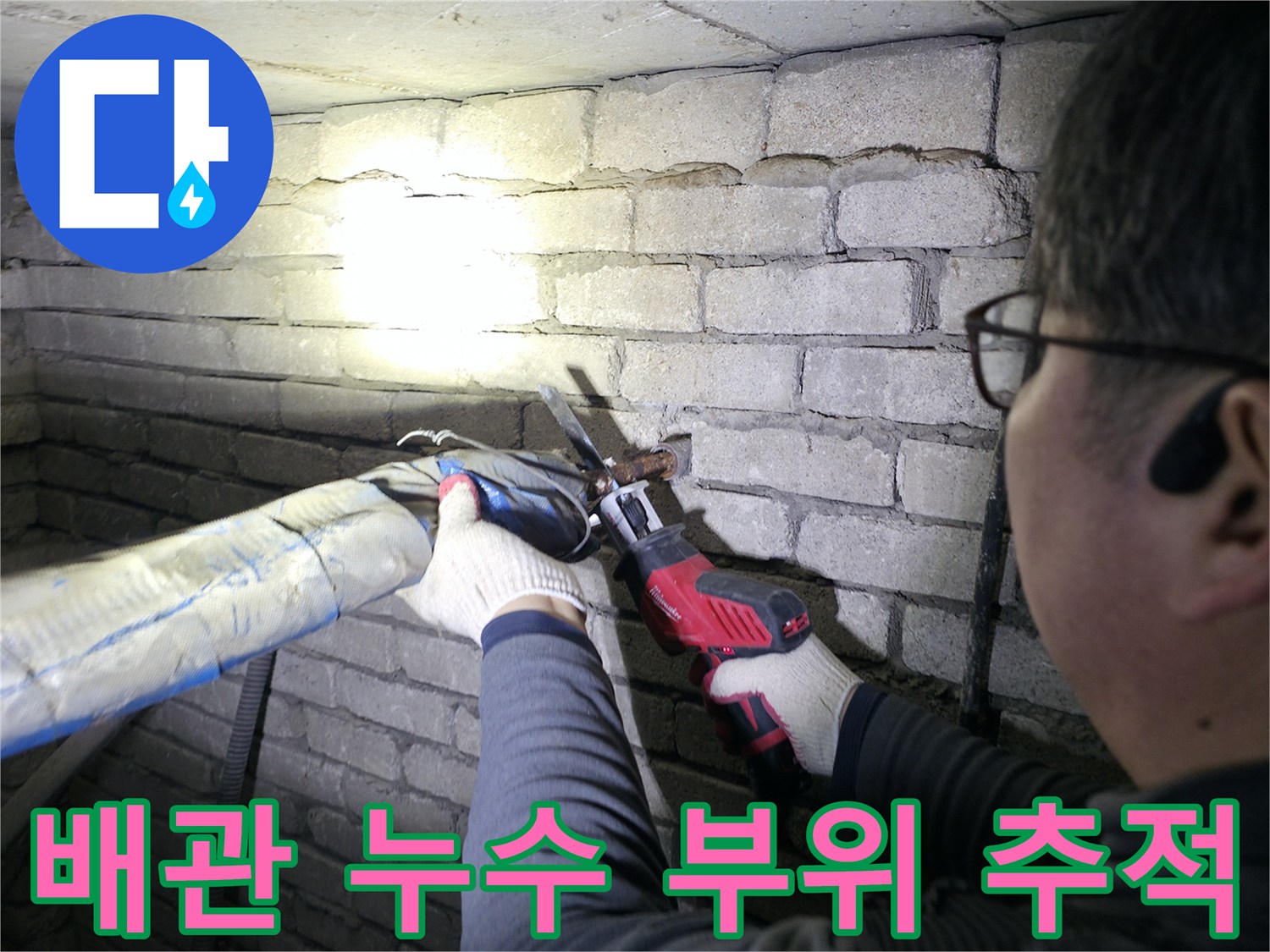 벽돌벽 아래-배관의 결함 부위를 조사하는 모습