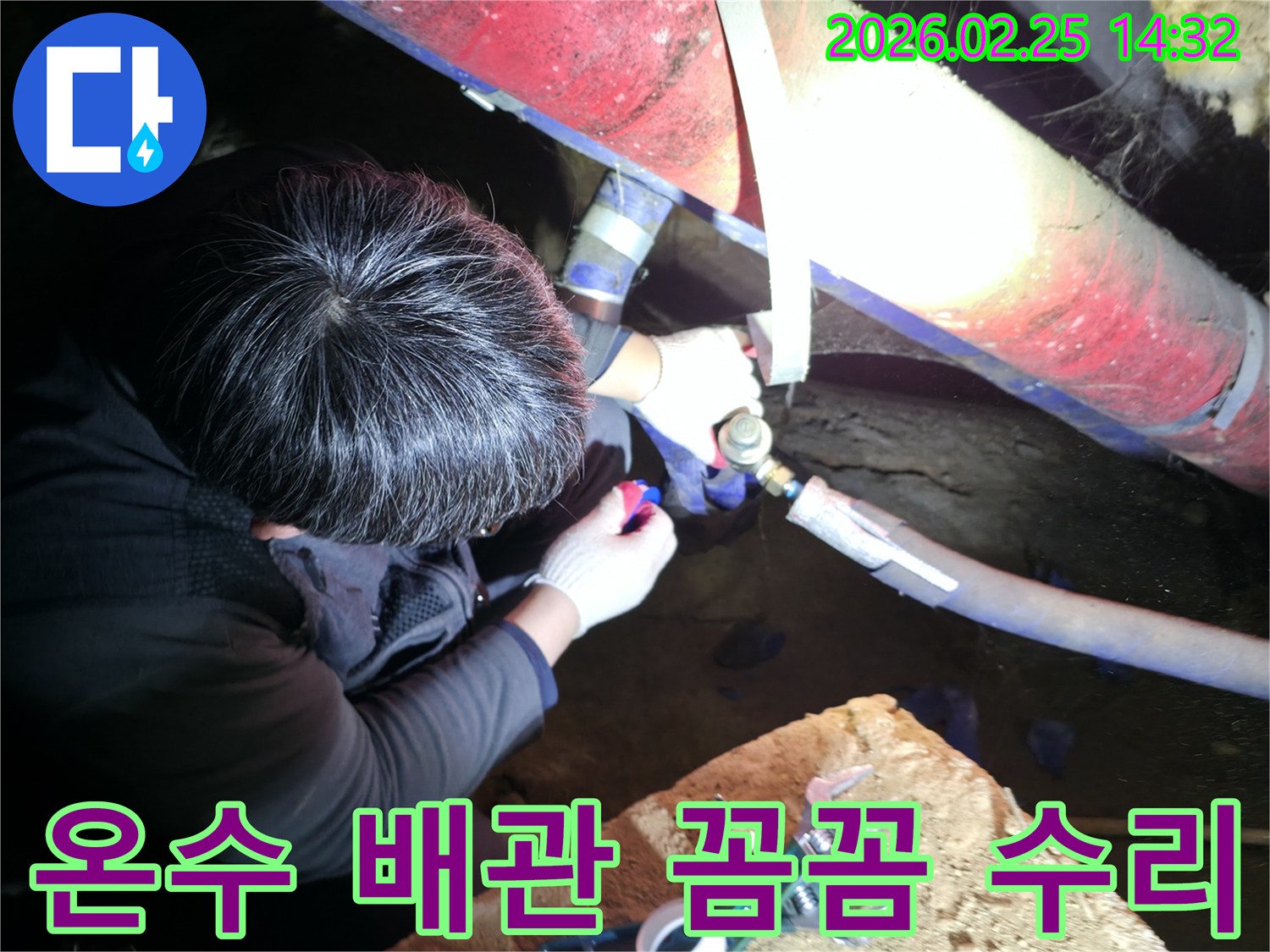 숙련된 누수 기술자가 좁은 공간에서 손전등을 비추며 온수 배관 연결 부위를 정밀하게 점검하고 꼼꼼하게 수리하고 있습니다-온수누수해결-전문가수리
