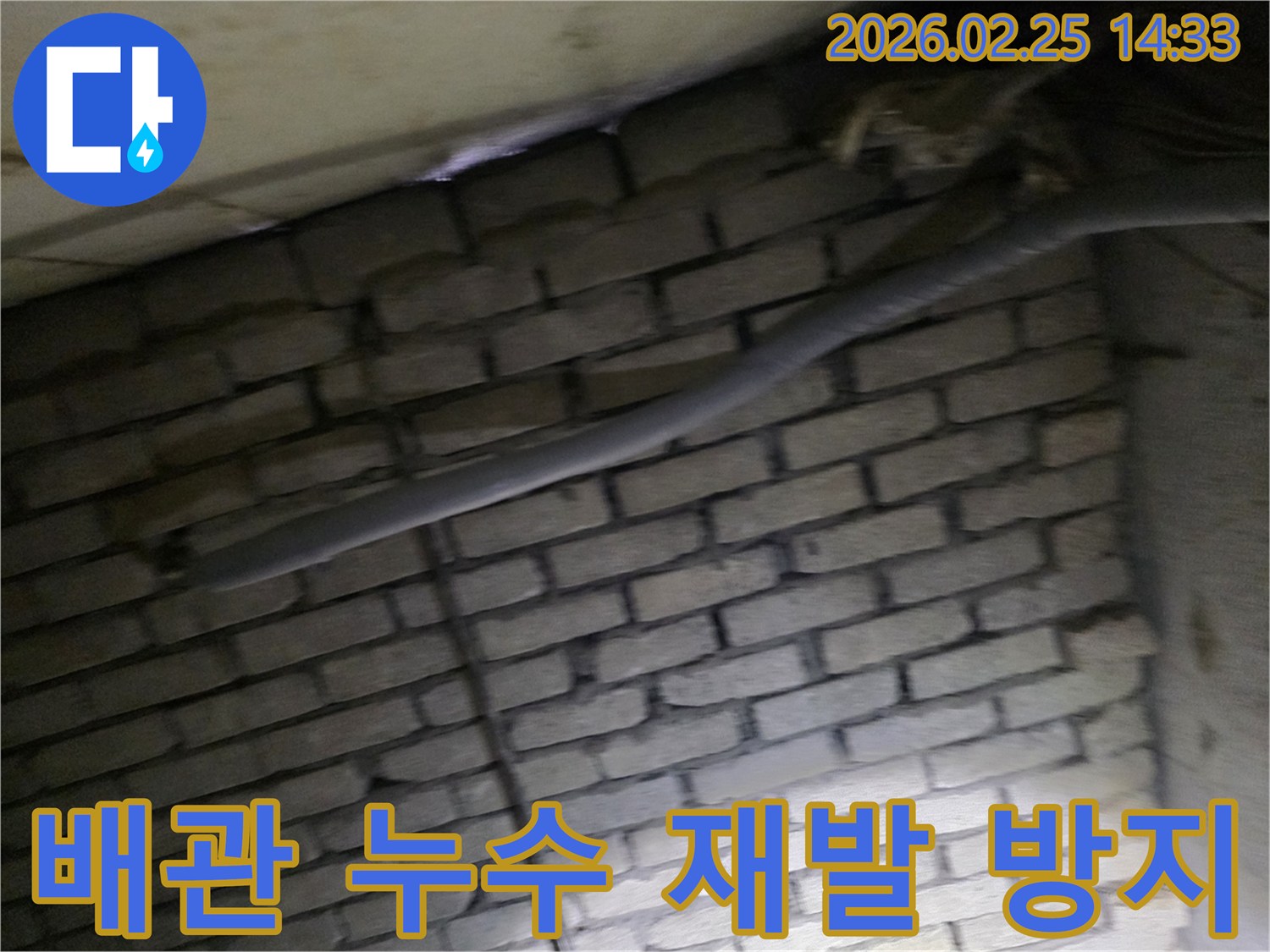 어두운 벽돌 벽면을 배경으로-단열된 배관과 함께-누수 지점을 탐지하고-재발 방지 대책을 세우는 현장 모습입니다.