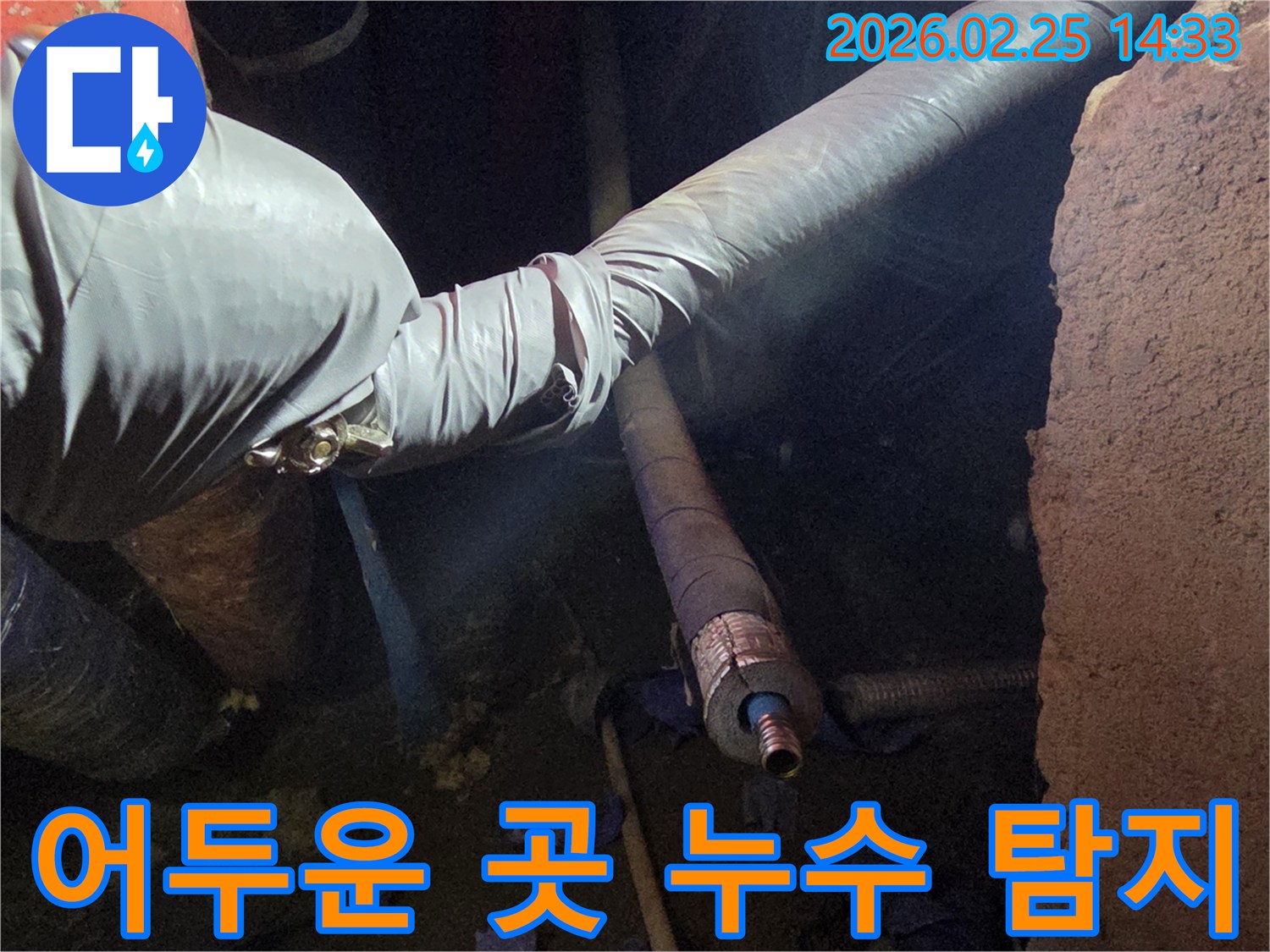 어두운 작업 공간에서-강력한 조명을-활용하여-배관의 미세한 누수 지점을-정확하게 찾아내는-모습입니다