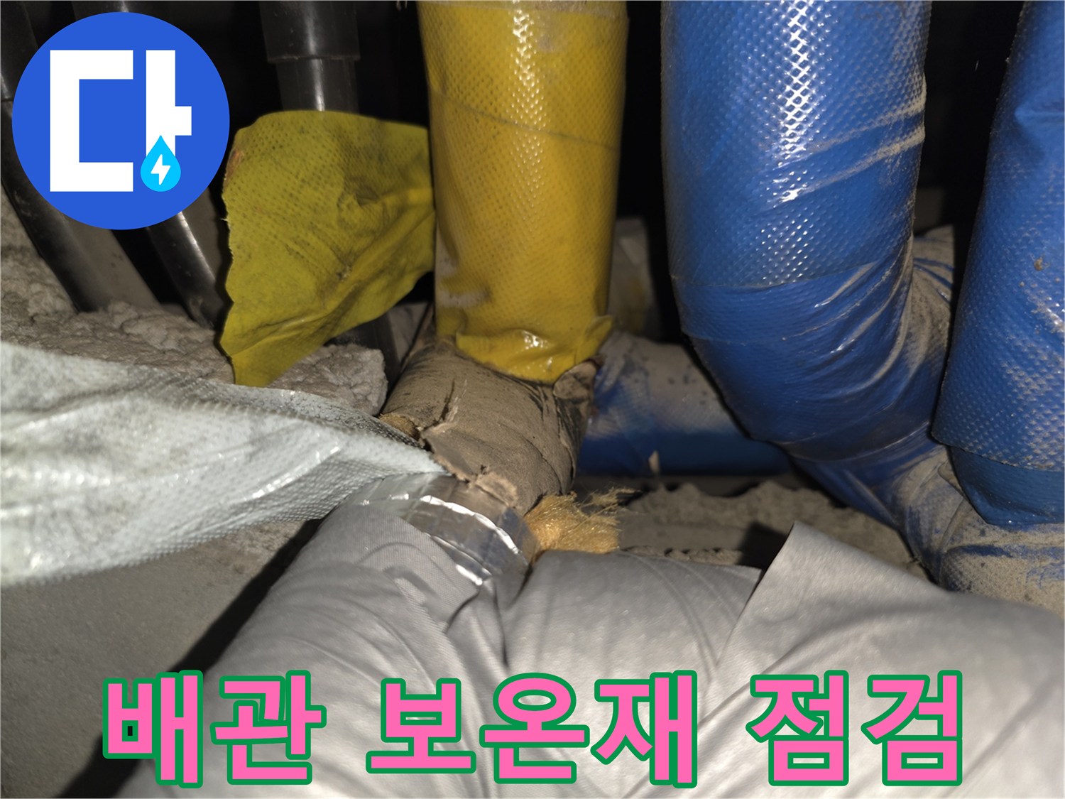 노란색과 파란색 보온재로 감싸진 배관 사이의 상태를 확인하는 모습