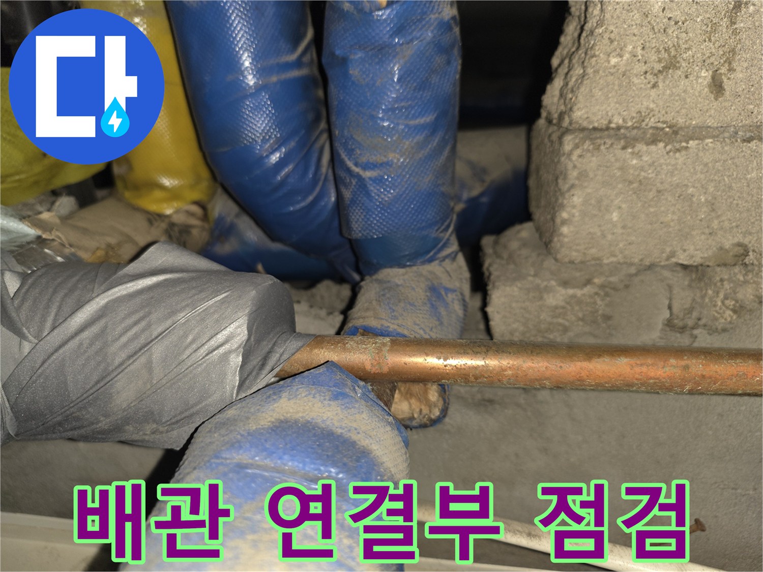 작업자가 장갑을 착용한 채 구리 배관 상태를 살피는 모습