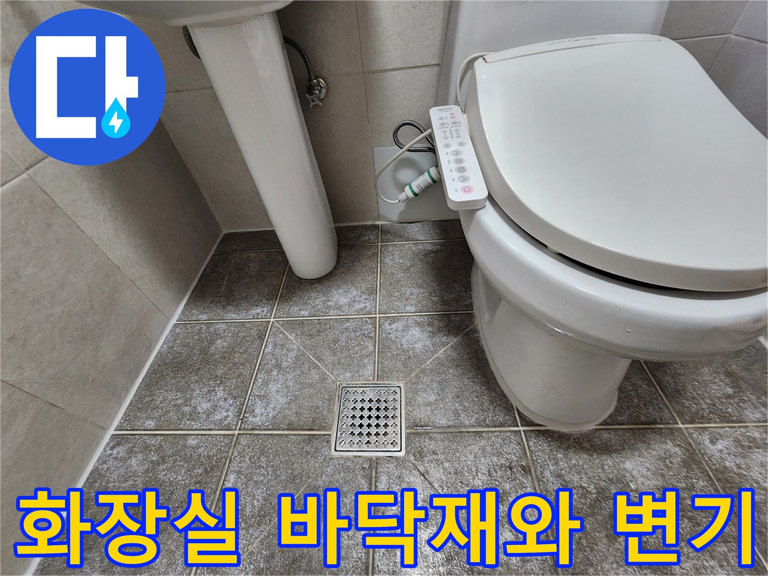 변기와 세면대 사이의 타일 바닥 및 배수구 사진