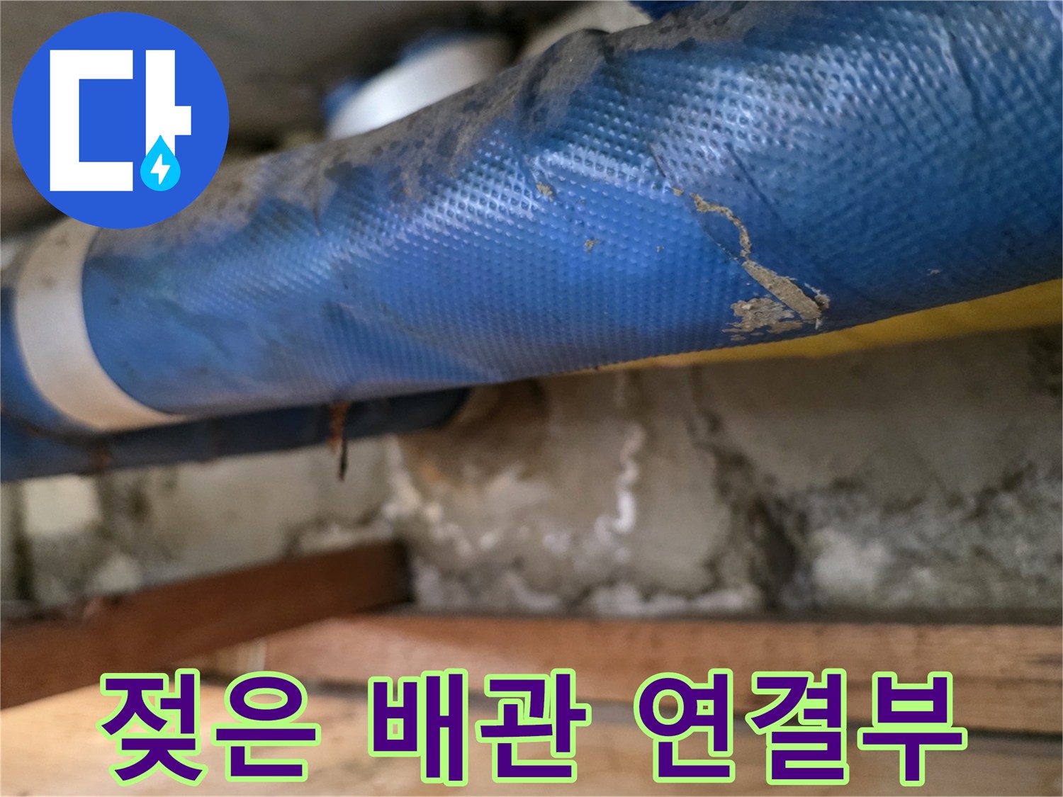 물기가 스며든 파란색 배관과 콘크리트 벽면 부위