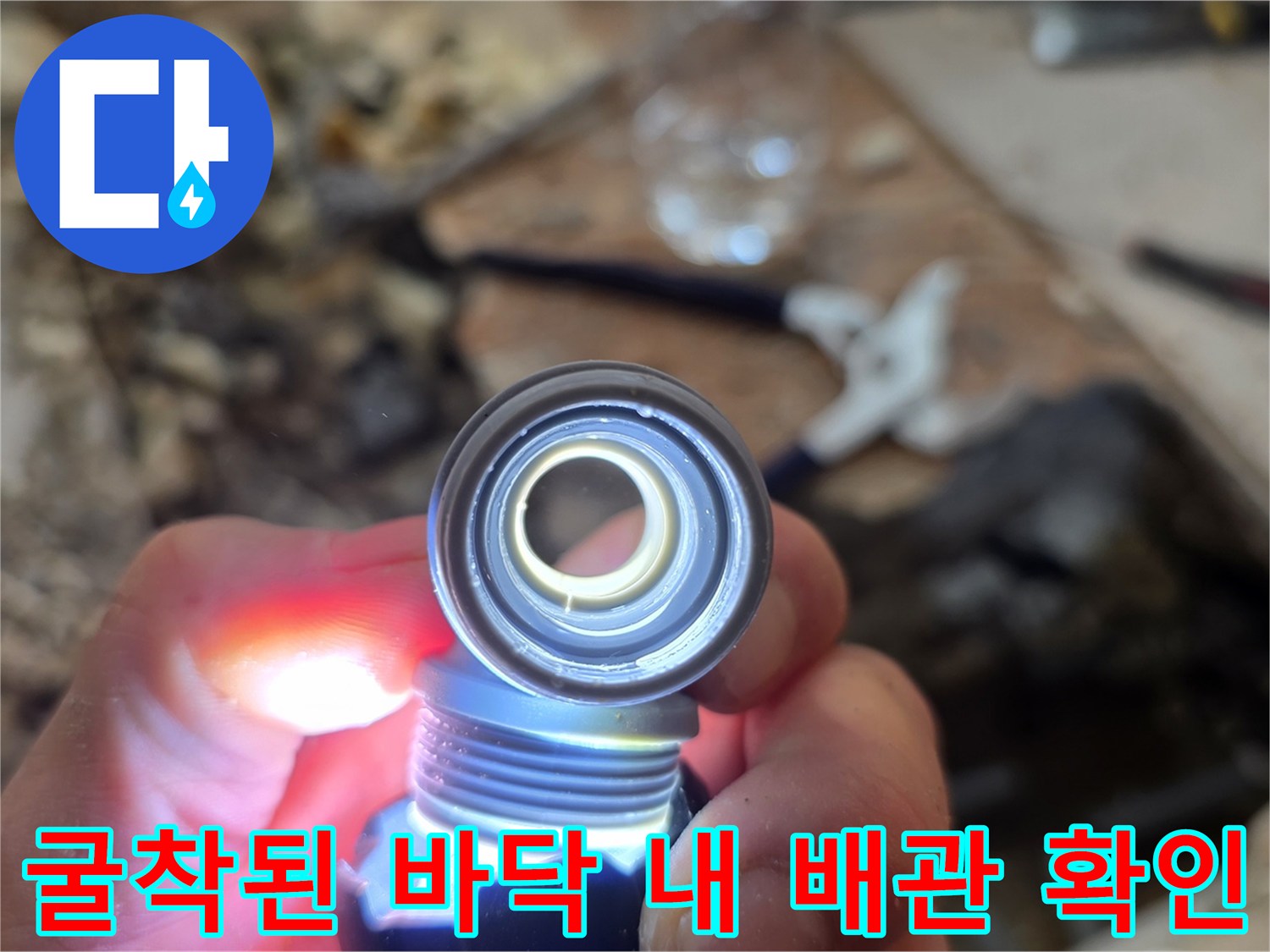 손전등으로 비춘 젖어 있는 배관 연결 부위