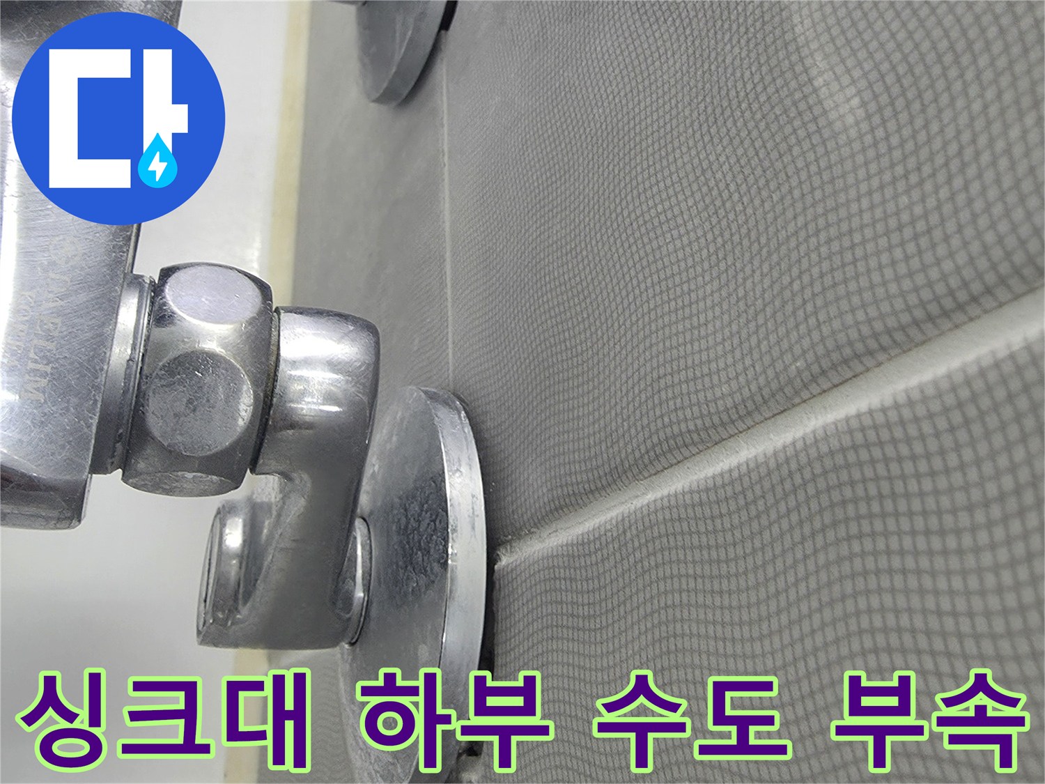 벽면 타일 아래 은색 금속 배관 연결 부위 상세 샷