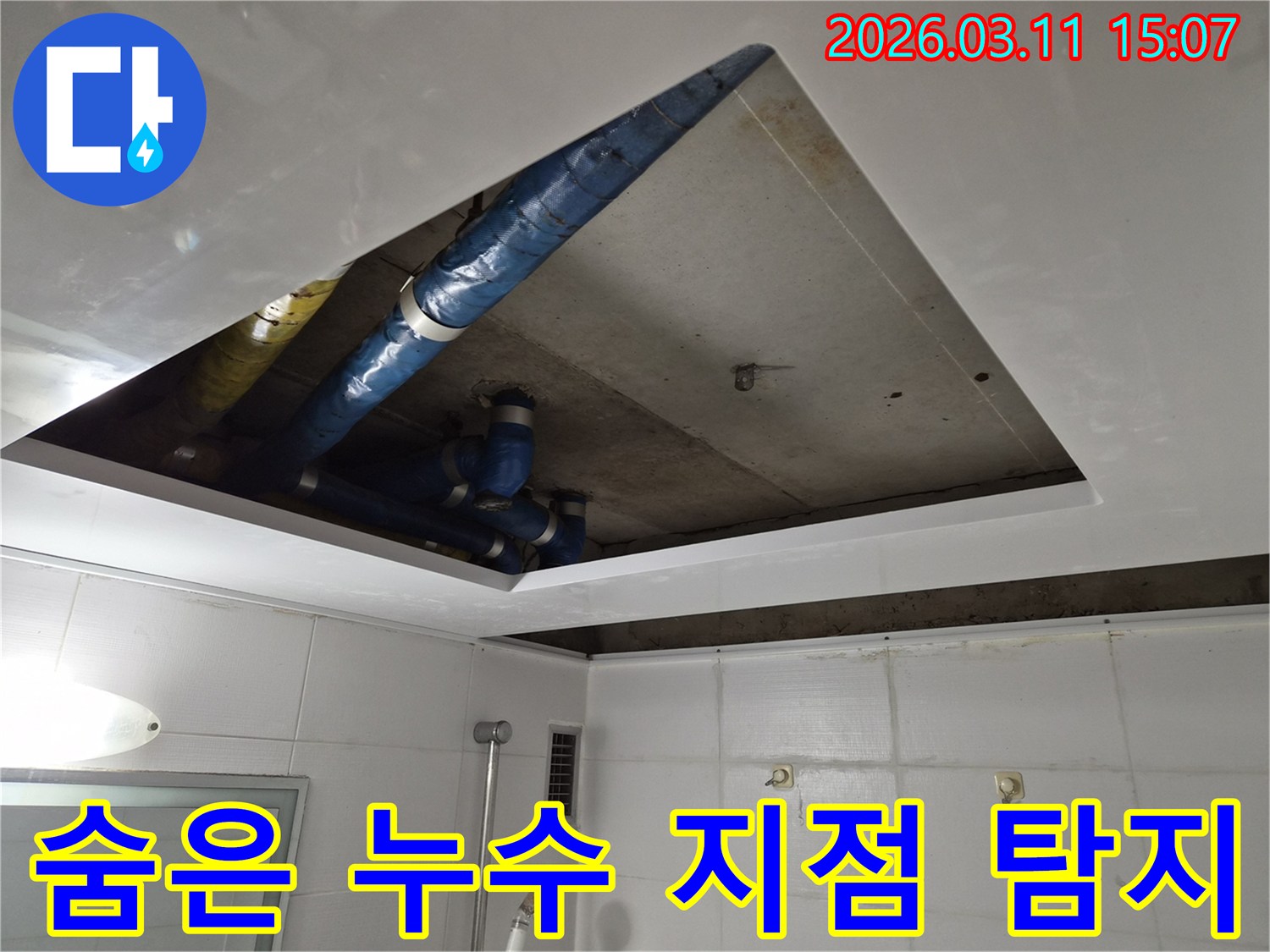 콘크리트 천장 아래로-복잡하게 연결된 배관들 속에서-누수의 정확한 위치를-찾아내기 위한 탐지 작업 현장입니다.