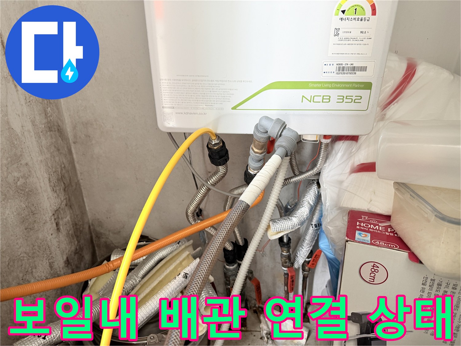 보일러 하단에 연결된 은색 배관과 노란색 호스