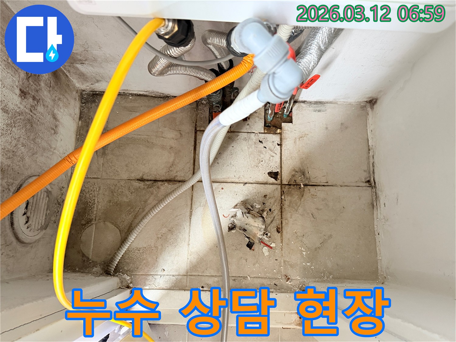 복잡하게 얽힌 배관들과-오염된 바닥 타일이-누수 발생 현장의-심각성을 보여줍니다.