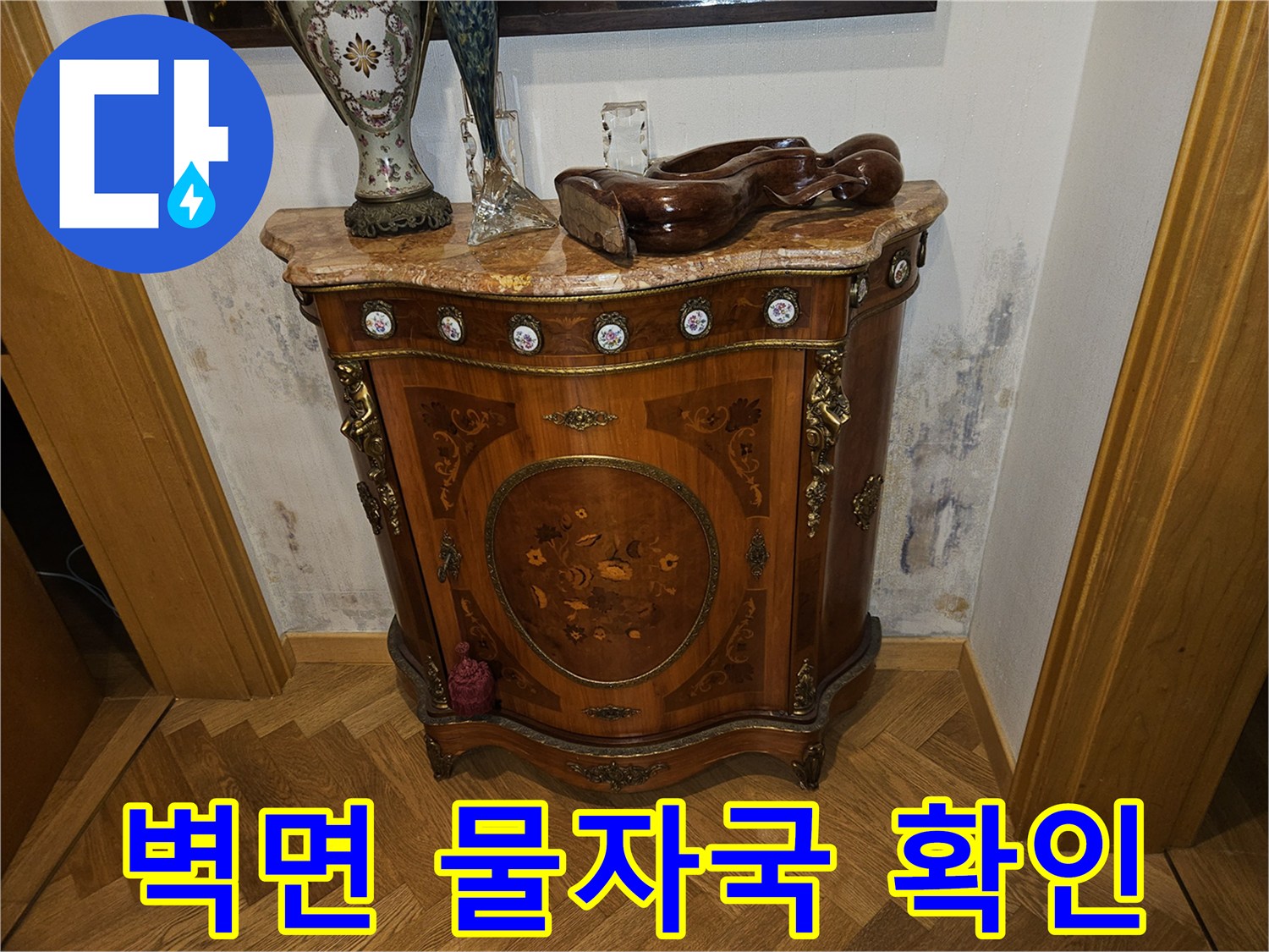 가구 뒤쪽 벽면에 나타난 누수 흔적과 얼룩