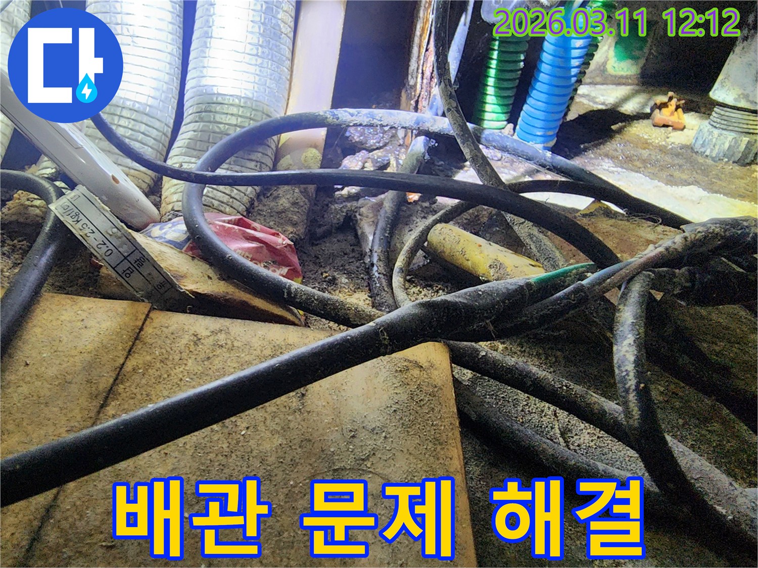 누수-공사 현장에서-복잡하게-얽힌-배관과-전선-사이의-작업-환경을-보여주는-사진입니다.