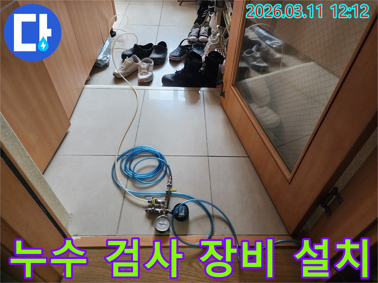 누수 탐지 작업을 위해 압력 게이지와 연결 호스를 바닥에 설치한 모습