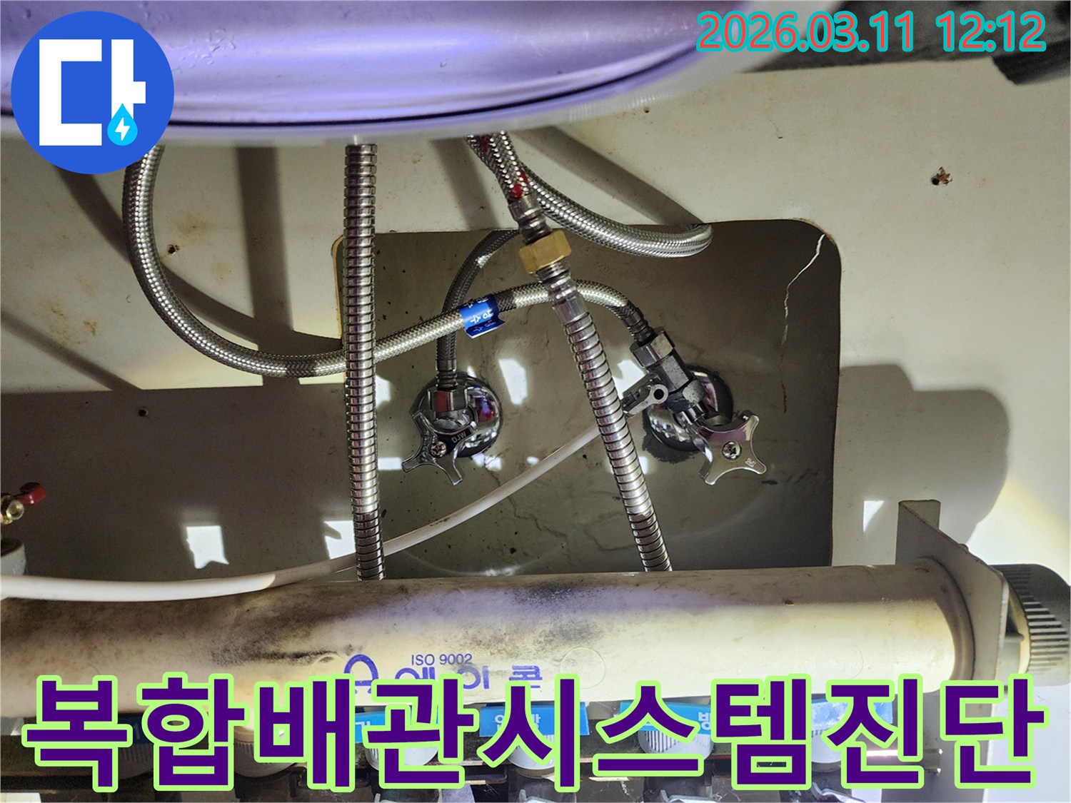 싱크대-하부의-다양한-수도-배관과-에어컨-분배기가-복잡하게-얽힌-부분을-누수-전문가가-진단하는-장면
