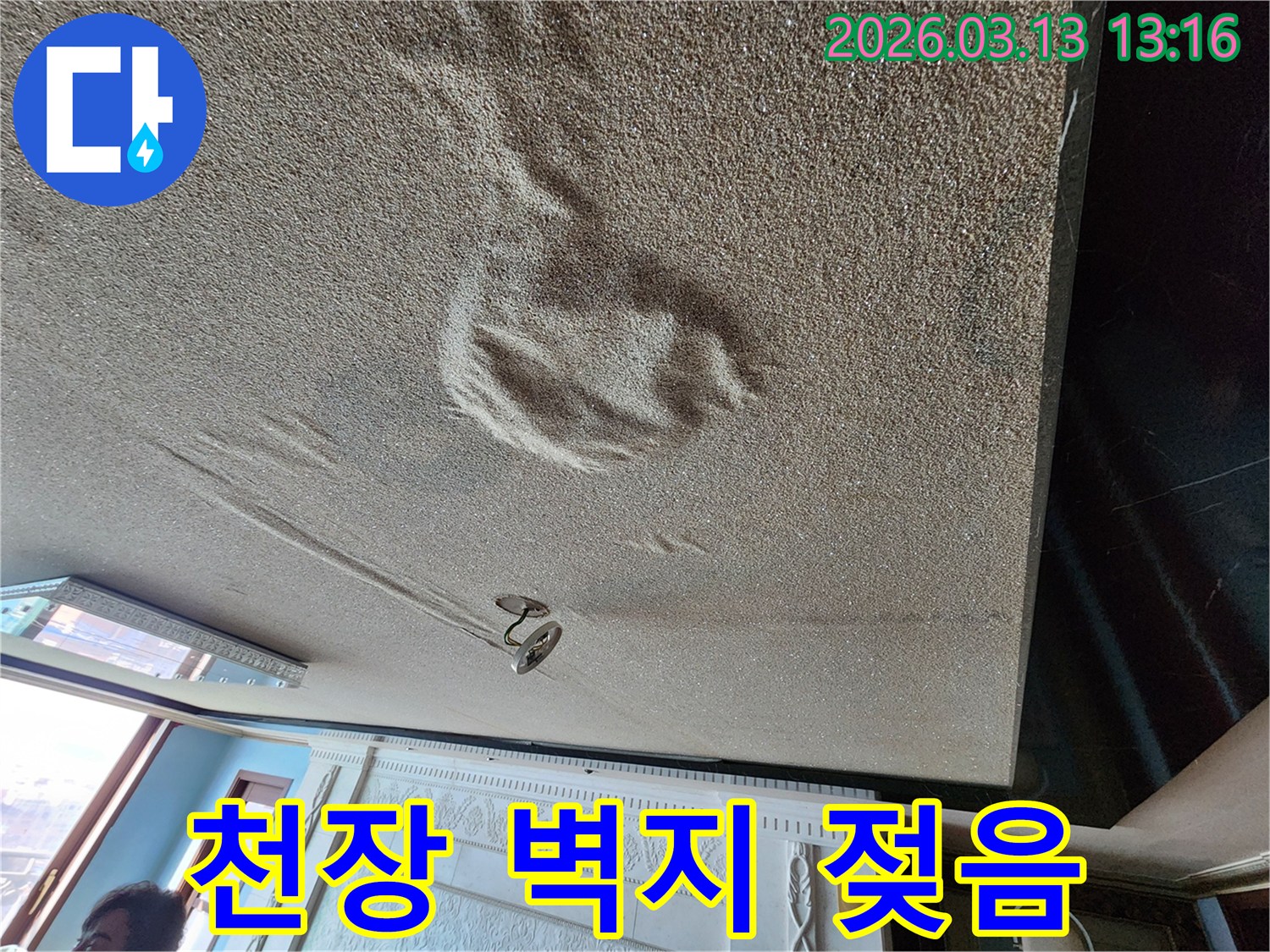 물에 젖어 변색되고 부풀어 오른 천장 벽지 마감재의 누수 현장