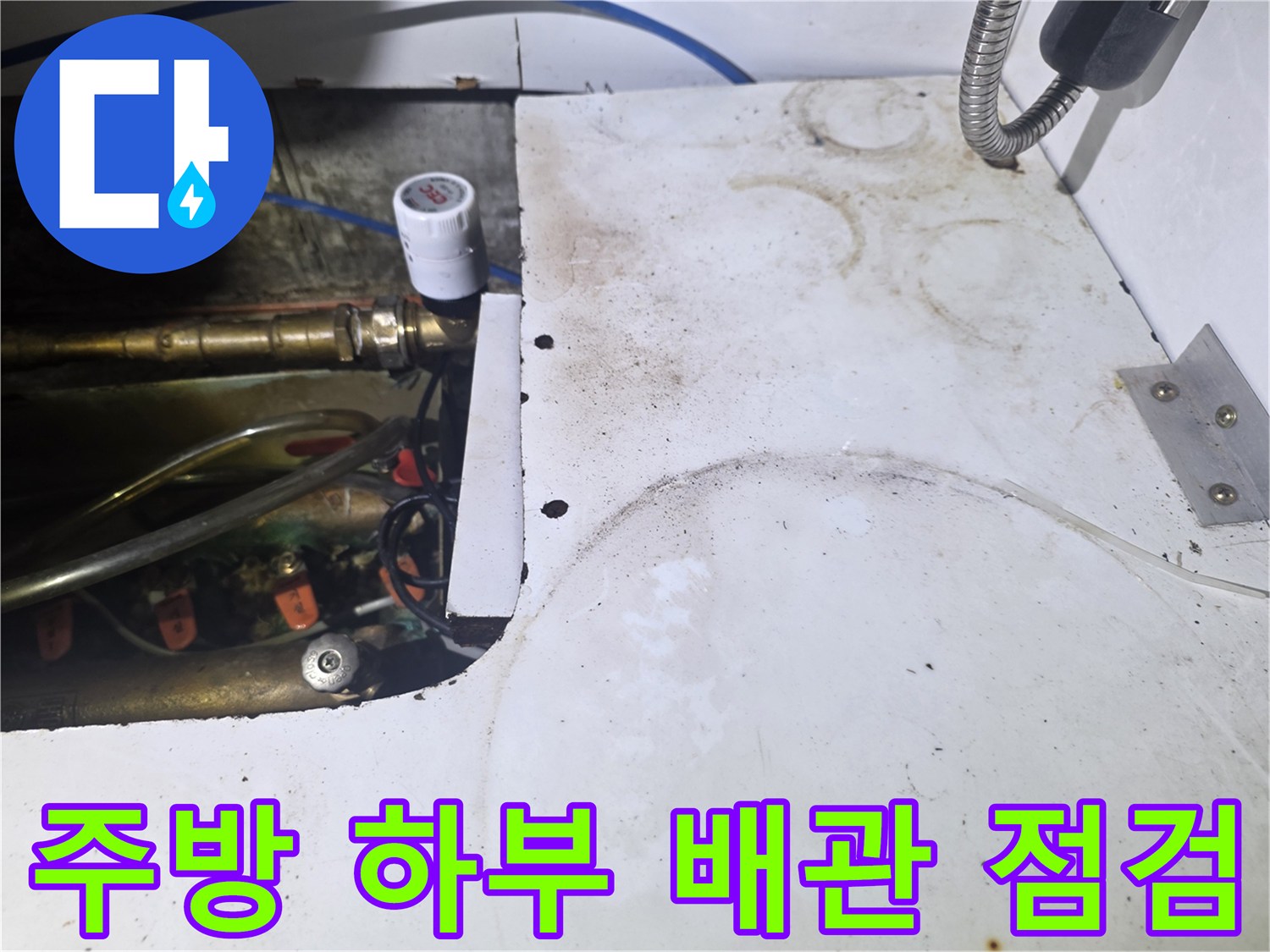 싱크대 밑 배관과 밸브가 복잡하게 연결된 현장 사진