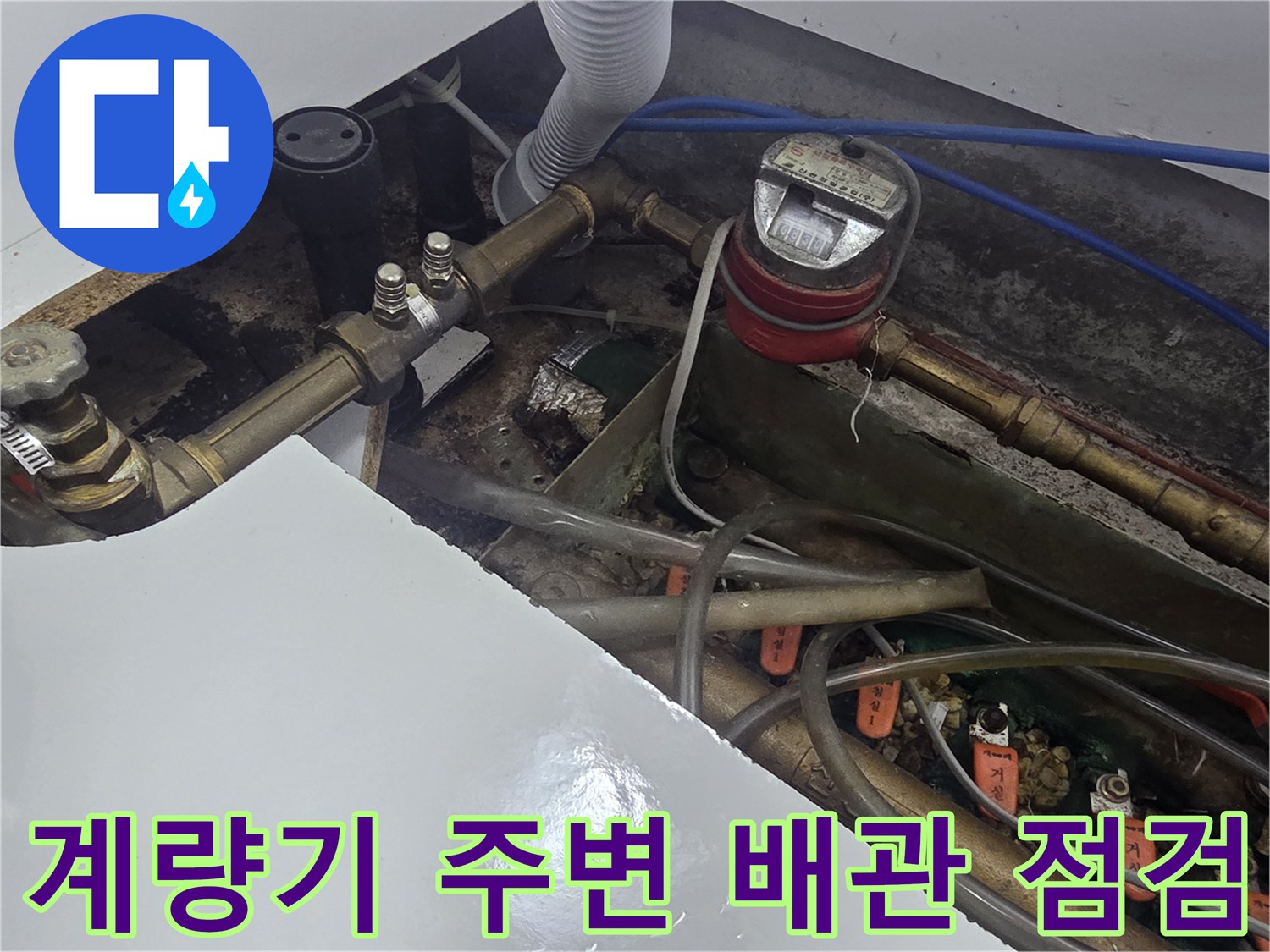 주방 하부 수도 계량기와 금속제 연결 배관의 모습