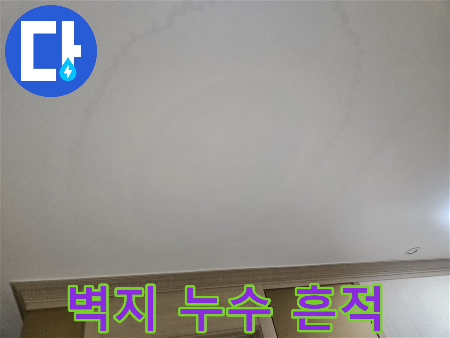 거실 천장 벽지를 타고 넓게 번져 있는 누수 얼룩 부위