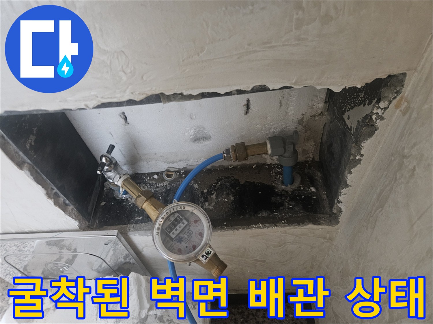 벽을 깨서 드러낸 파란색 배관과 압력 측정기 연결 상태