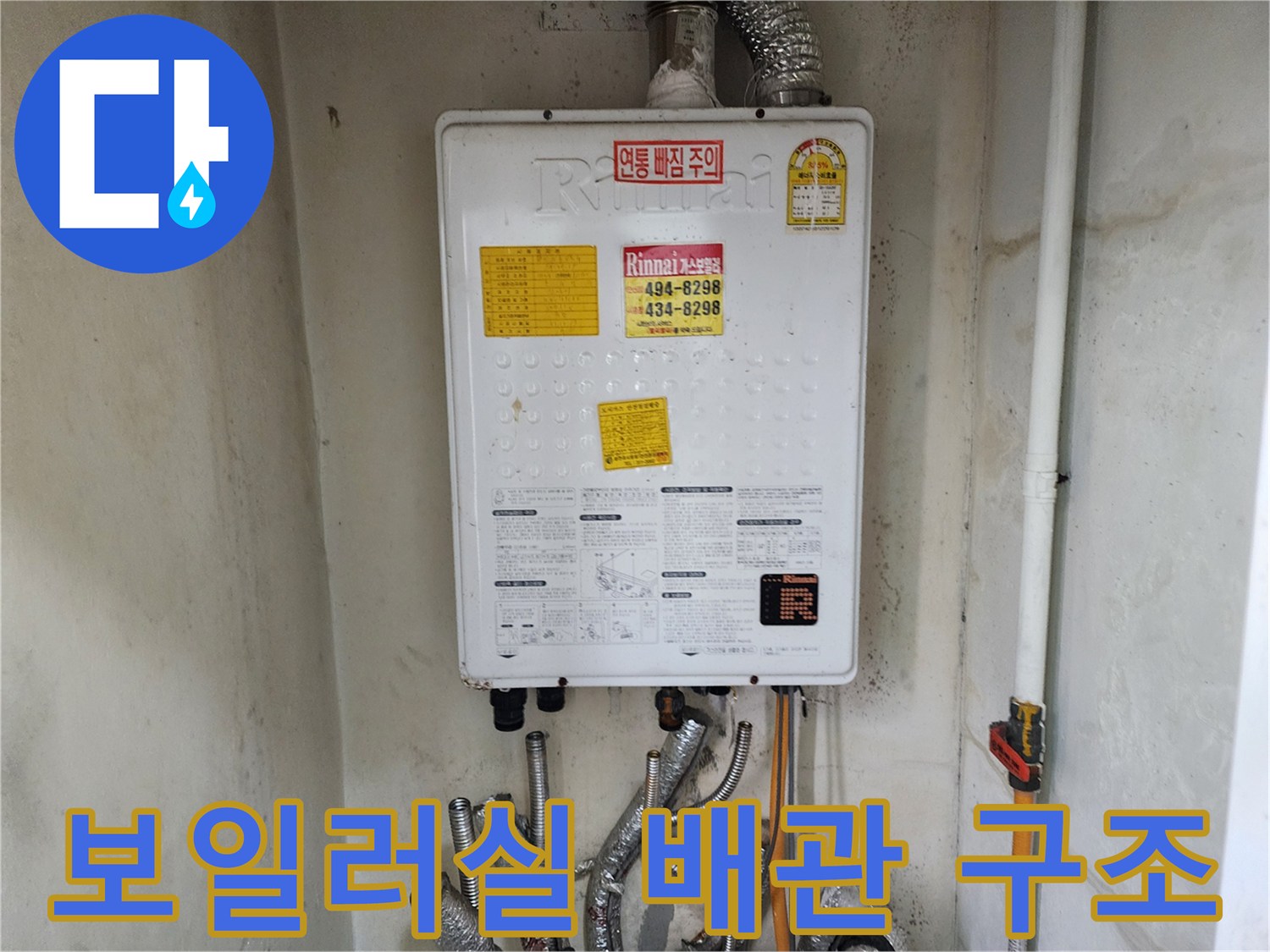 보일러 하단의 금속 배관 및 연결 부위 상세 사진